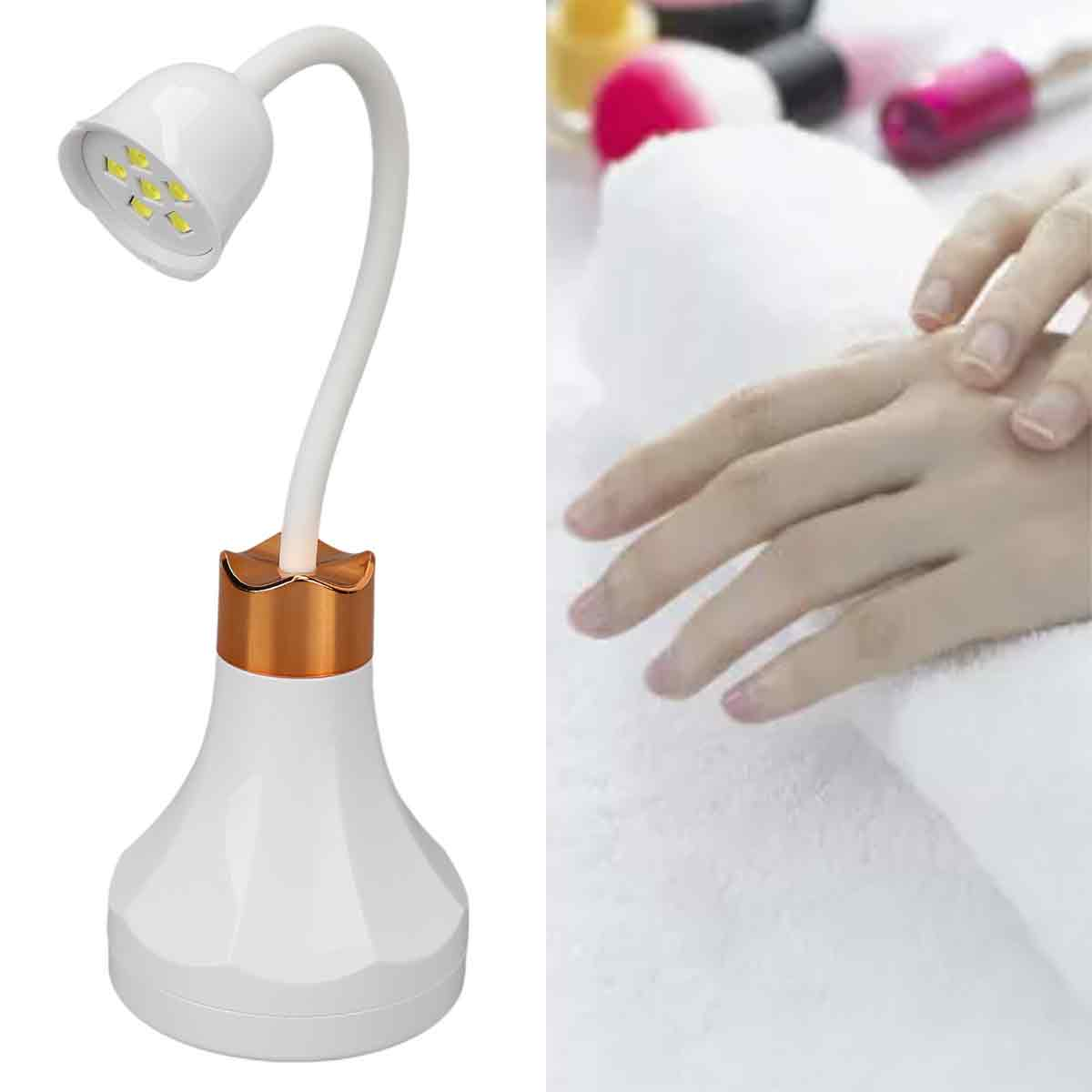 Eine weiße LED-Nagellampe neben einer Hand, die auf einem weißen Handtuch ruht. Nagellackflaschen befinden sich im Hintergrund.