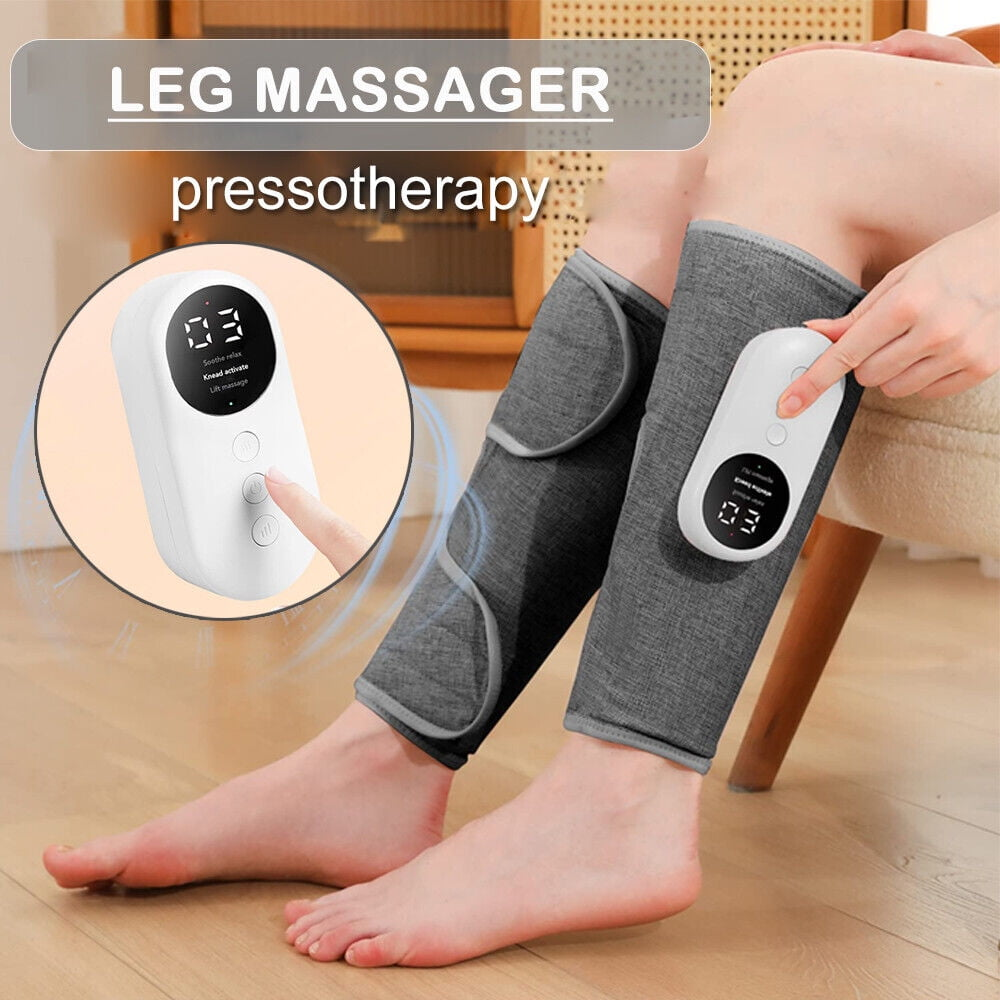 Eine Person benutzt ein Beinmassagegerät. Graue Wickel bedecken die Beine. Eine weiße Steuerung wird gehalten. Im Hintergrund sind Holzmöbel zu sehen.