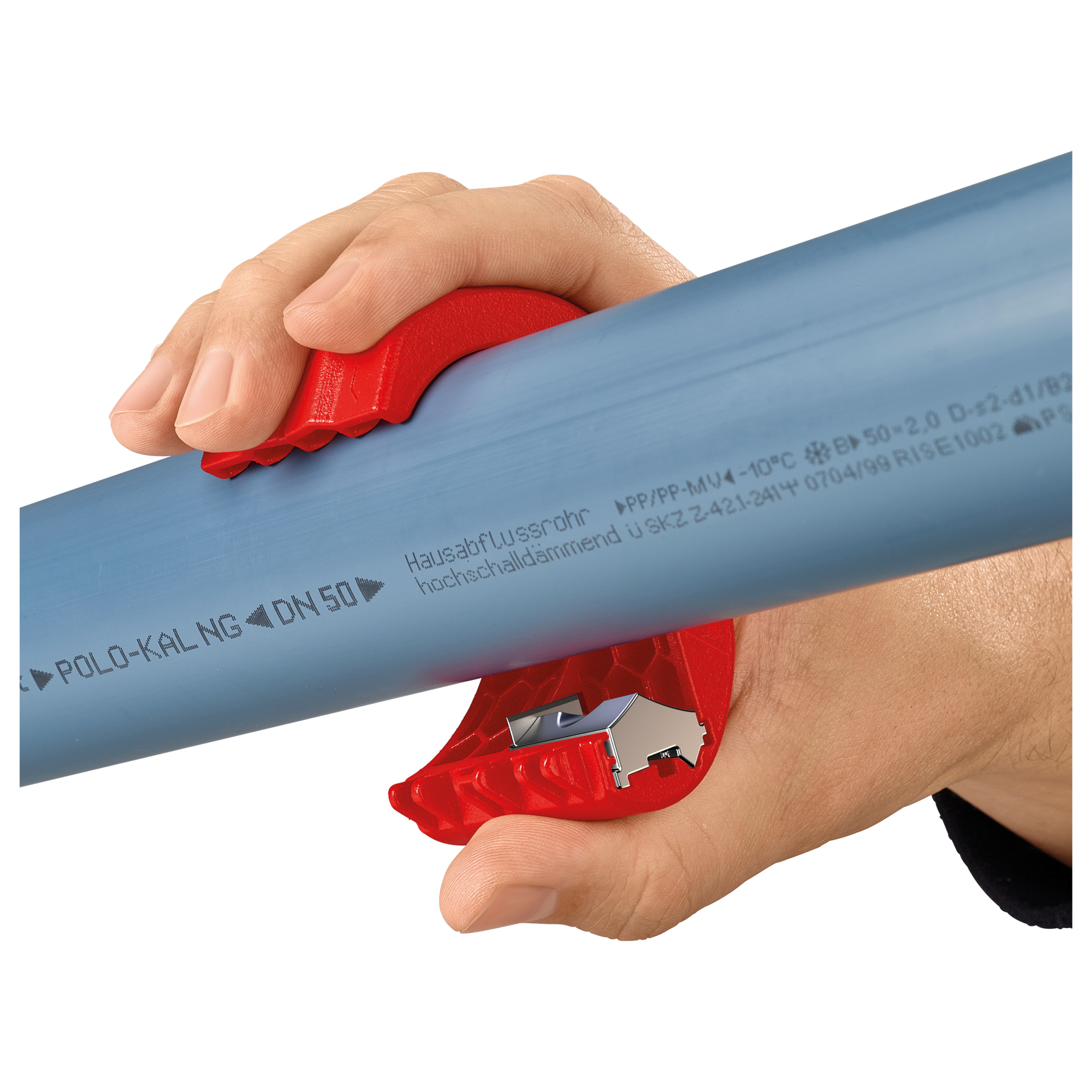 A hand holds a blue pipe with a red pipe cutter. The cutter is cutting the pipe. White background.