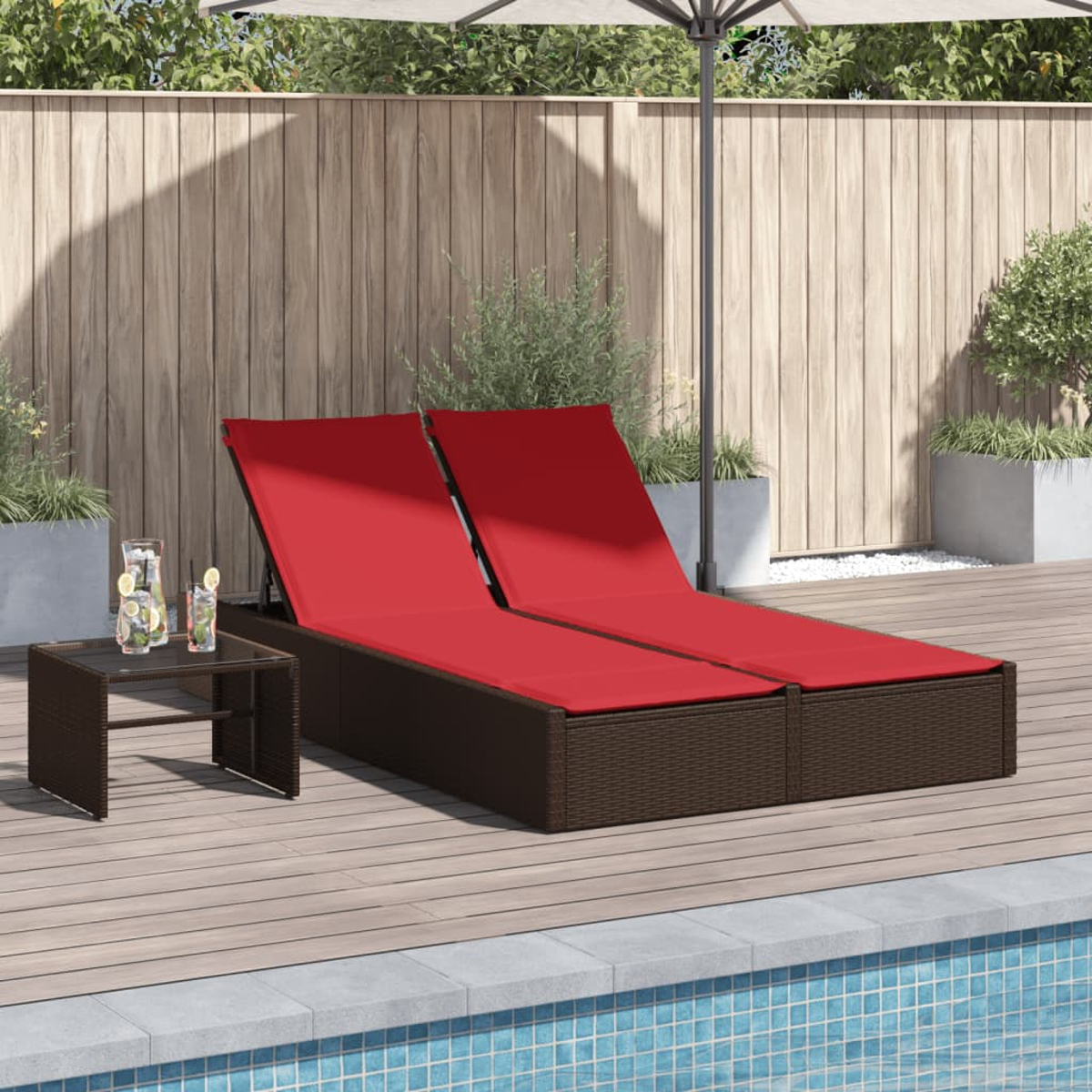Zwei rote Liegestühle am Pool, mit einem Beistelltisch und Getränken. Ein Holzzaun und ein Sonnenschirm sind im Hintergrund.