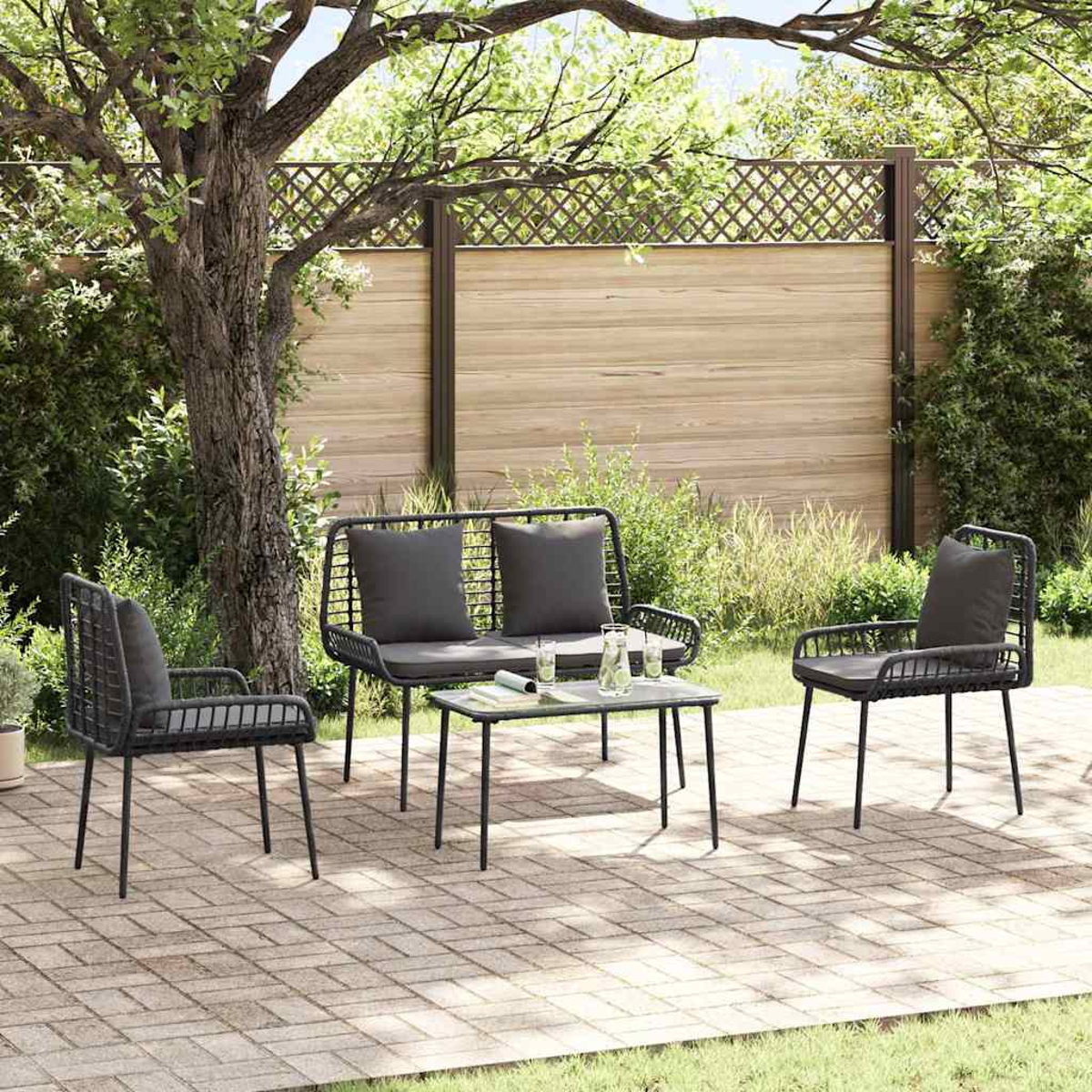 Terrassenset mit dunkelgrauen Kissen auf einer Backsteinterrasse. Enthält ein Sofa, zwei Stühle und einen Tisch, alle mit schwarzen Rahmen.