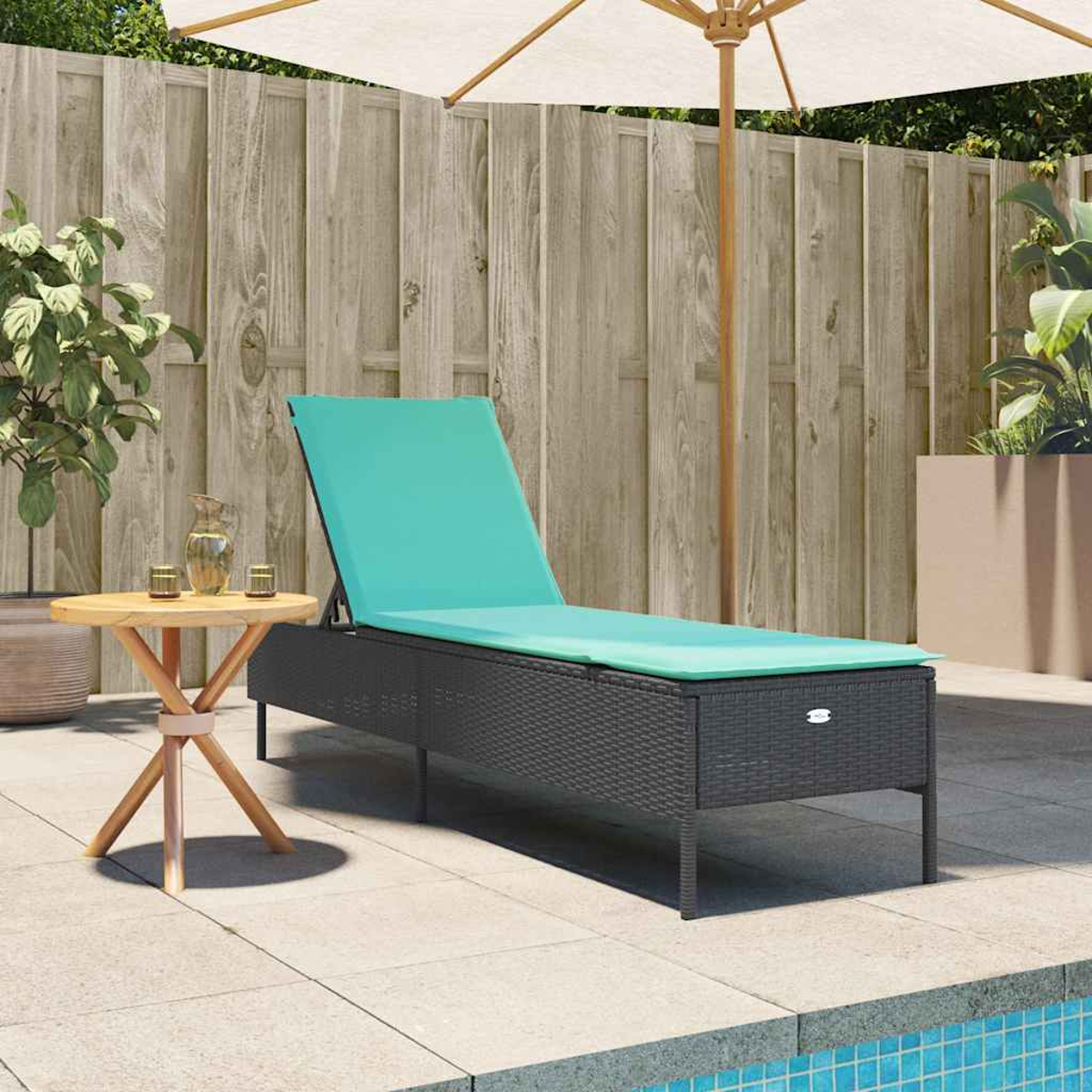 Eine Terrasse mit einer Chaiselongue mit türkisfarbenem Kissen, einem kleinen Tisch und einem offenen Sonnenschirm. Ein Pool befindet sich im Vordergrund.