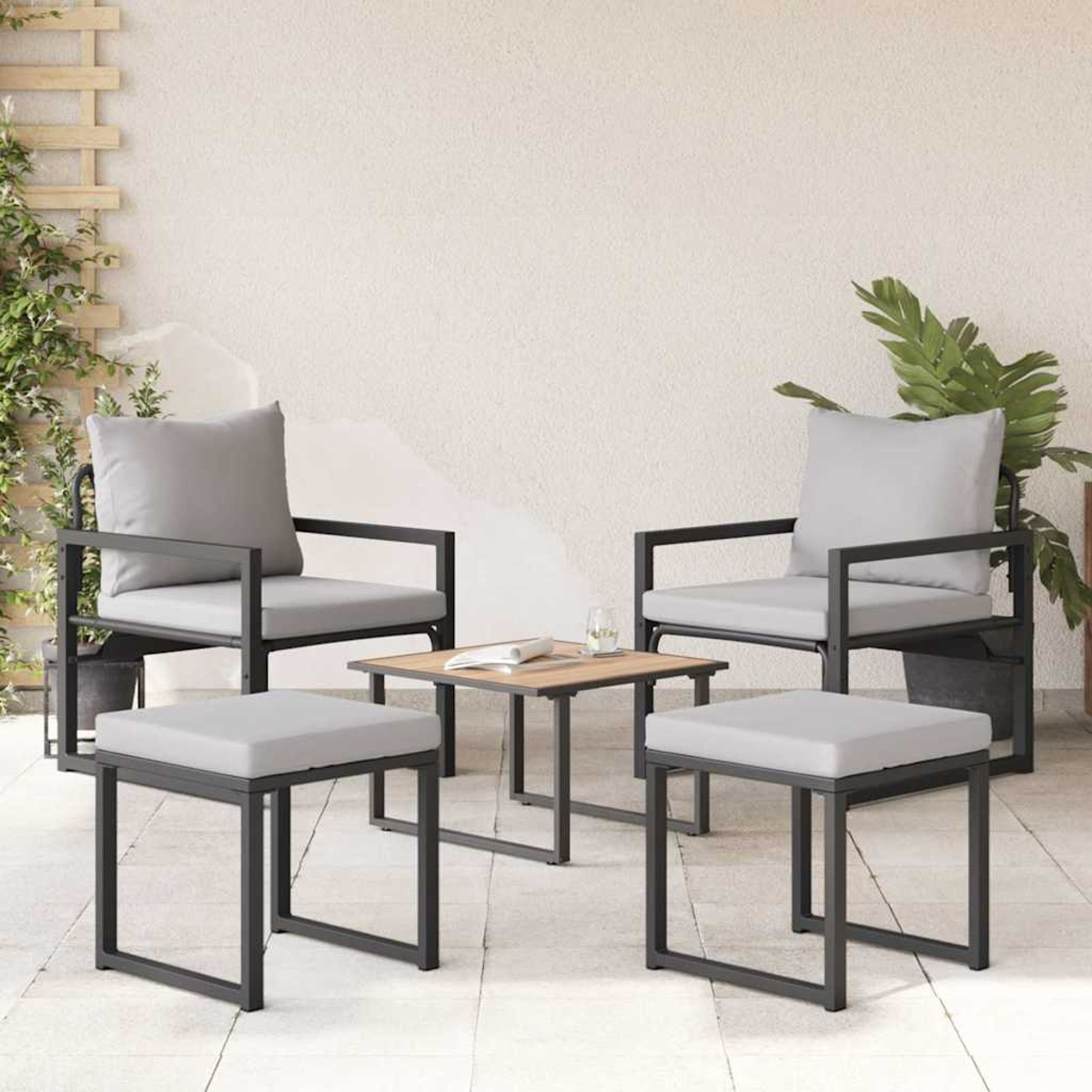 Terrassenset mit zwei Stühlen, zwei Hockern und einem kleinen Tisch. Graue Kissen, schwarze Rahmen und ein neutraler Hintergrund.