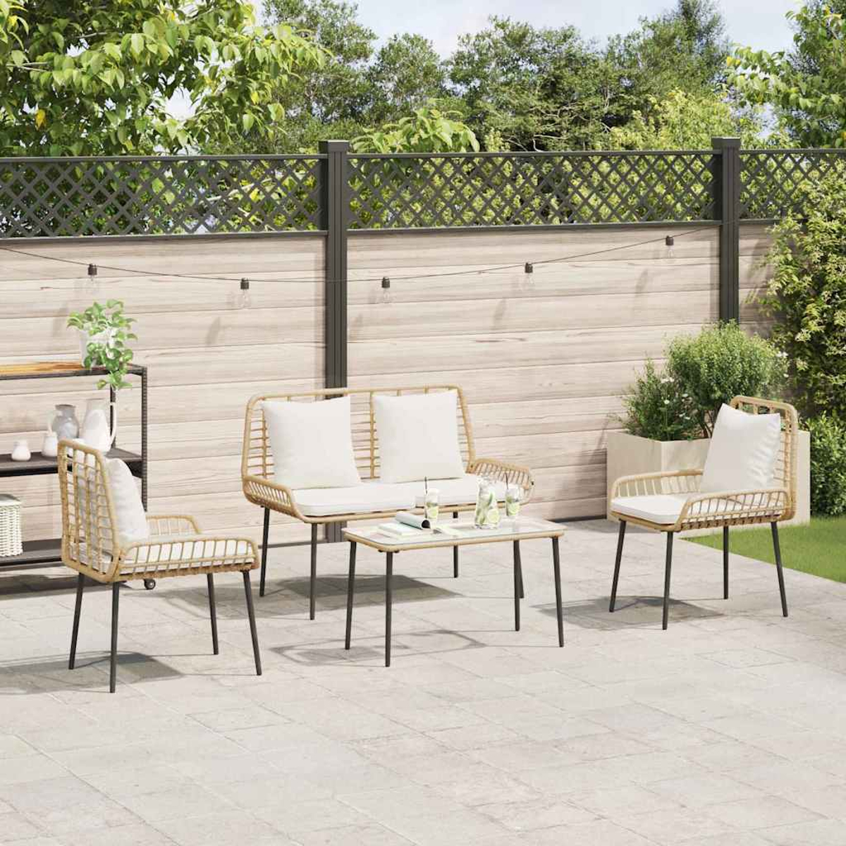 Eine Terrasse mit Sitzgruppe, Couchtisch und Holzzaun. Die Stühle und das Sofa haben weiße Kissen. Pflanzen sind vorhanden.