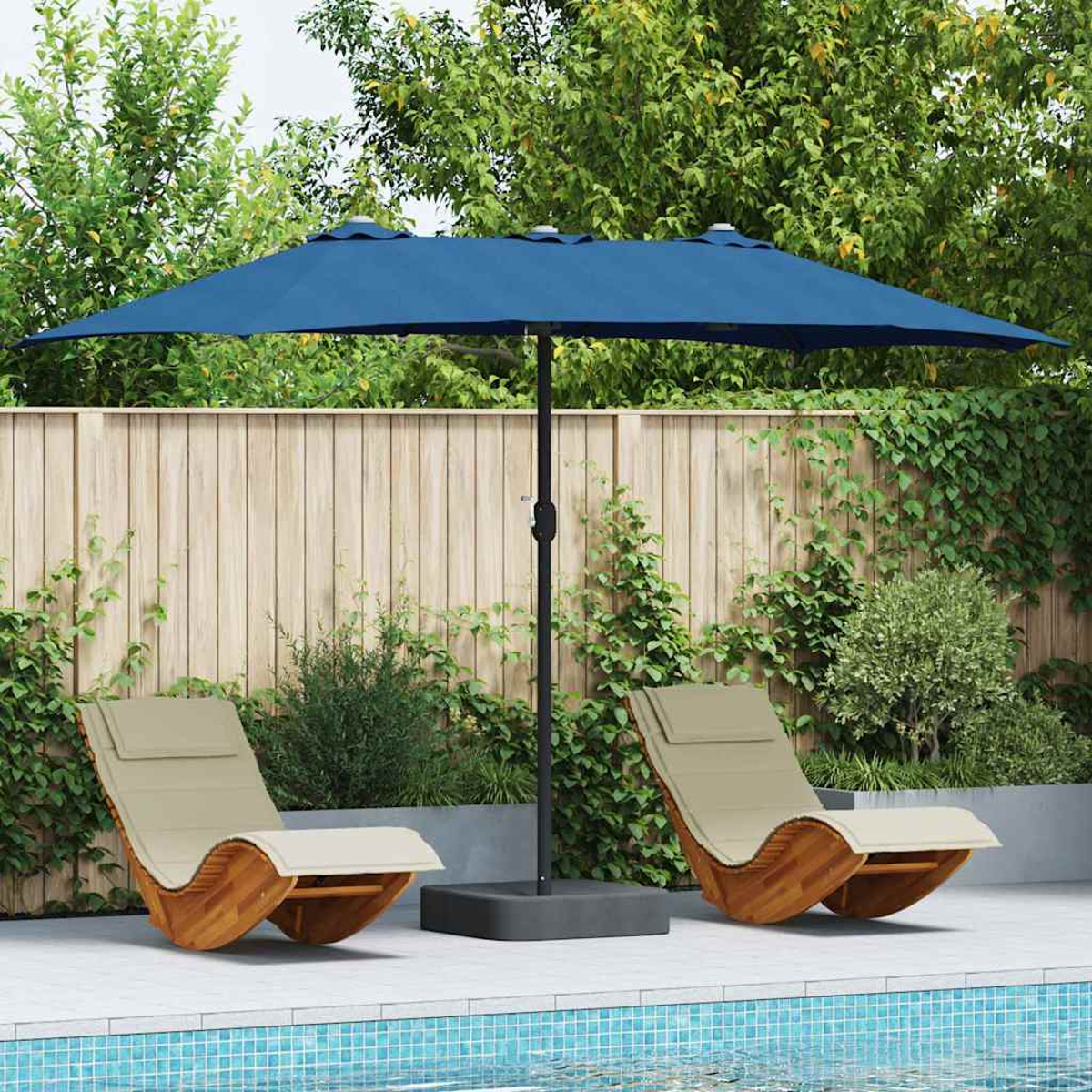 Un ombrello blu ombreggia due sedie a sdraio beige vicino a una piscina. Una staccionata di legno e fogliame verde formano lo sfondo.