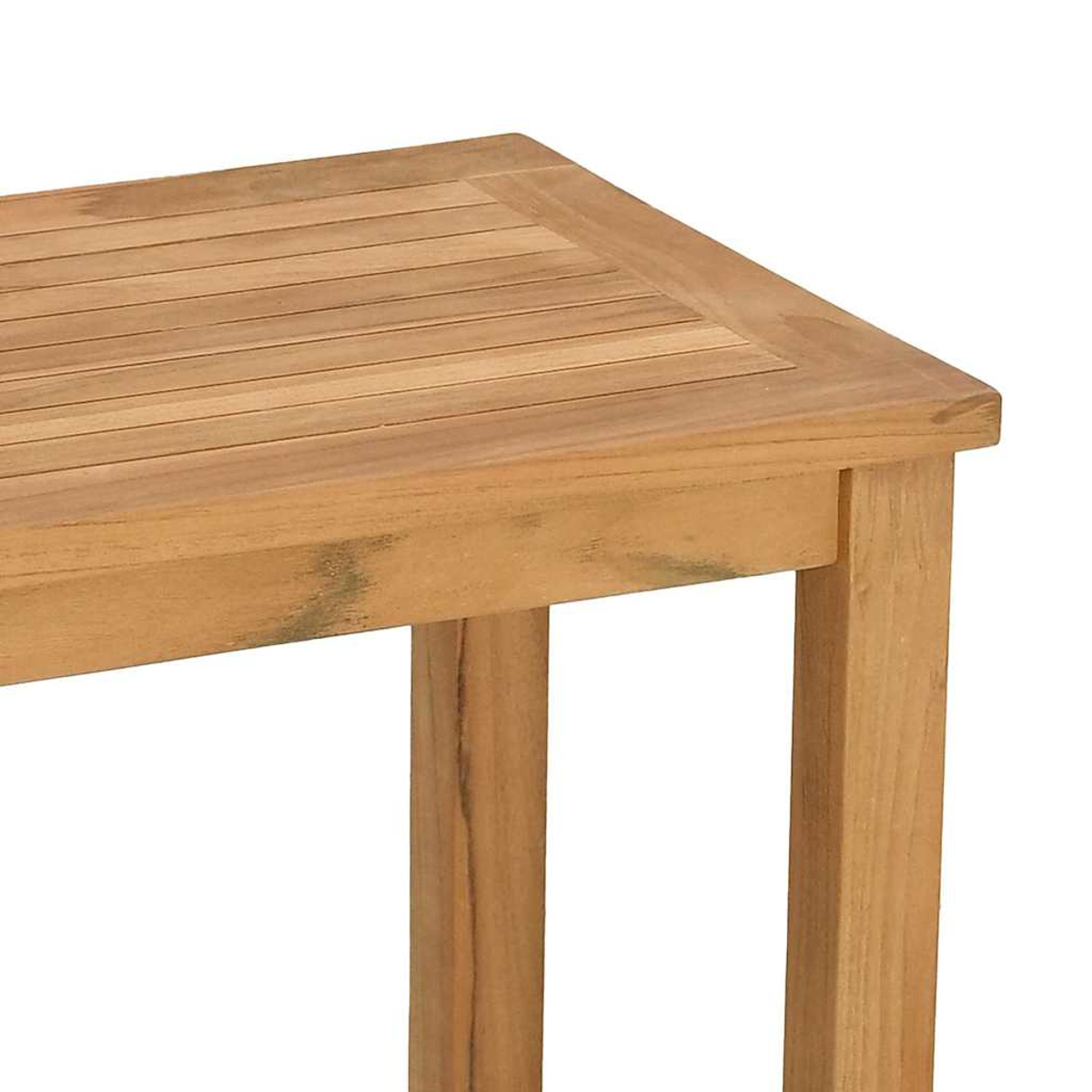 Esquina de mesa de madera. Color marrón claro, veta de madera visible. La parte superior tiene listones horizontales. Dos patas visibles a la derecha.