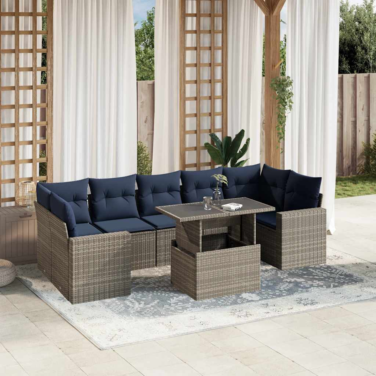 Outdoor-Ecksofa mit marineblauen Kissen und einem grauen Tisch auf einem gemusterten Teppich, Vorhänge im Hintergrund.