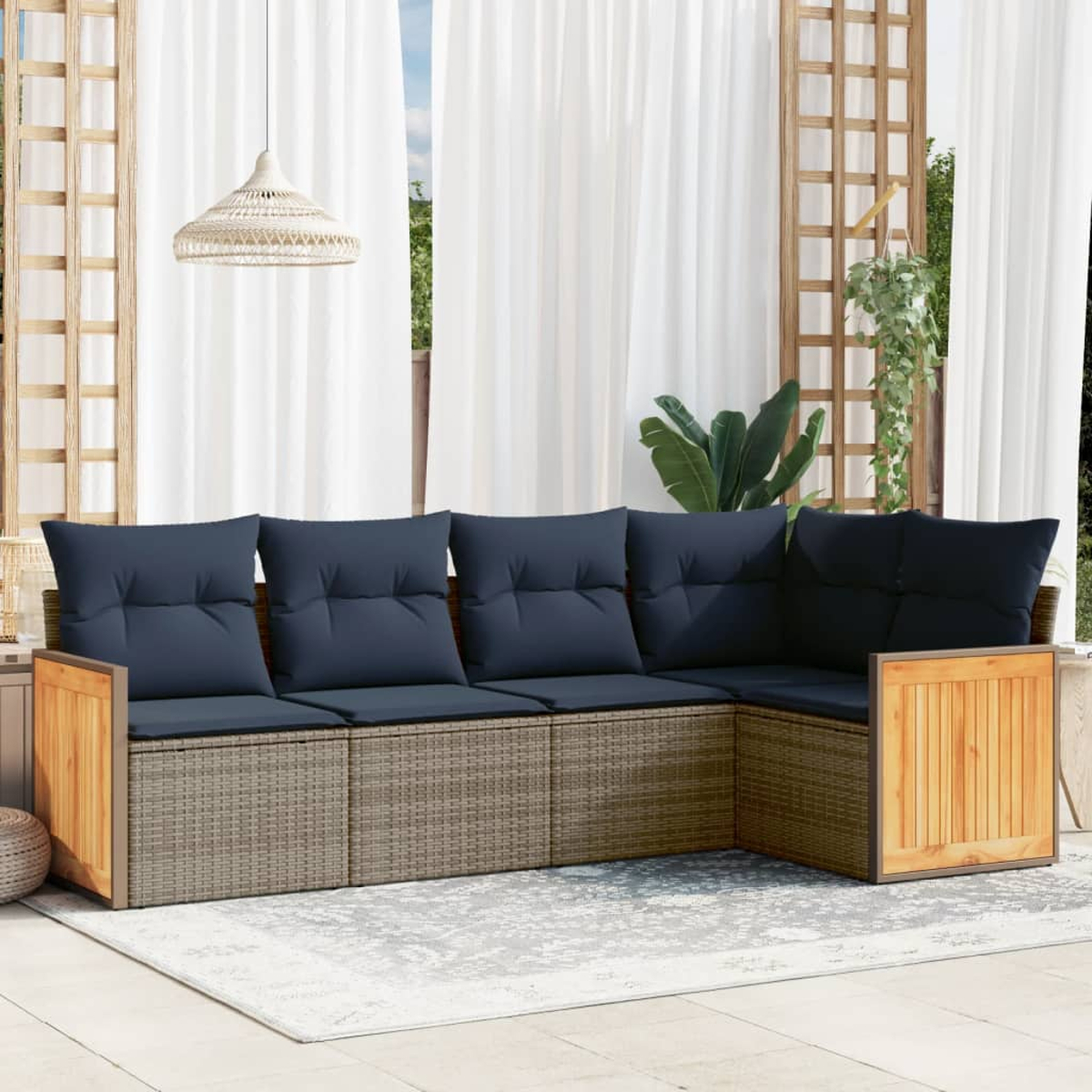 Outdoor-Ecksofa mit blauen Kissen und gewebter Basis. Der Hintergrund umfasst weiße Vorhänge, Pflanzen und eine Hängeleuchte.