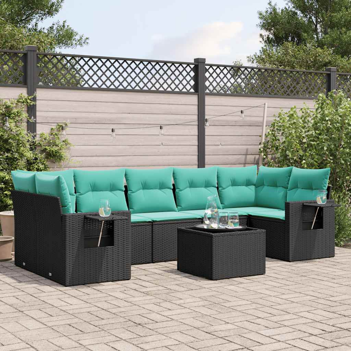 Outdoor-Ecksofa mit tealfarbenen Kissen und schwarzem Korbgewebe. Quadratischer Tisch mit Gläsern. Holzzaun im Hintergrund.