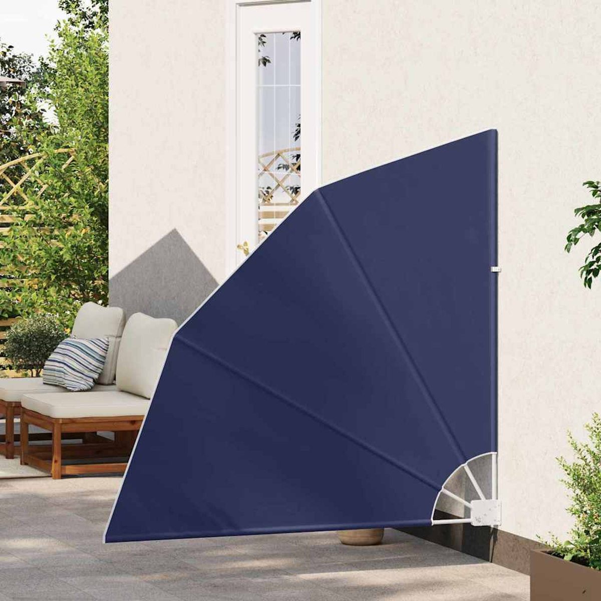 Ein marineblaues, dreieckiges Sonnensegel ist an einer cremefarbenen Wand angebracht. Im Hintergrund ist eine Tür zu sehen. Eine Terrasse mit Möbeln.
