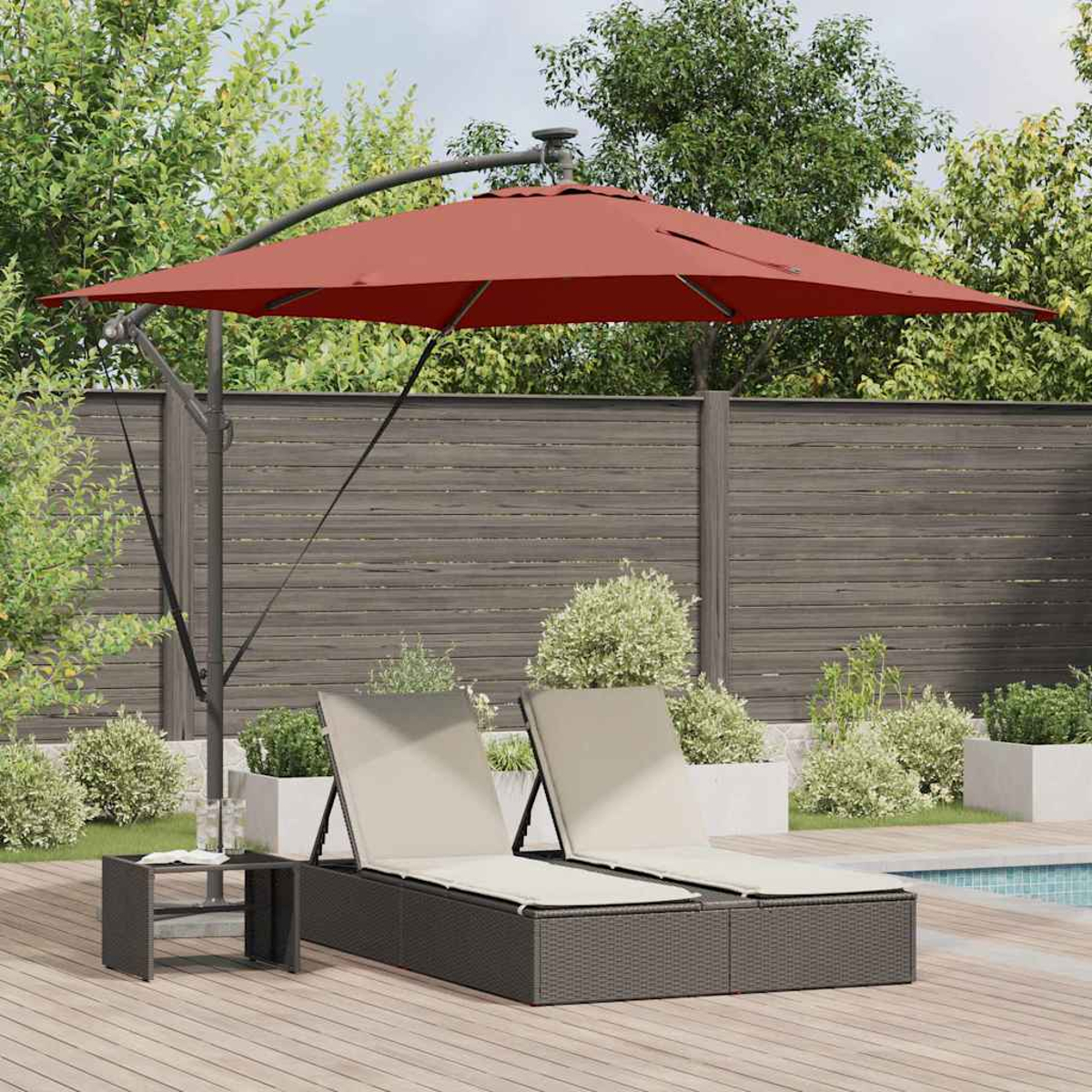 Scena all'aperto con un ombrellone rosso che ombreggia due sedie a sdraio. Un tavolino si trova vicino su una terrazza di legno.