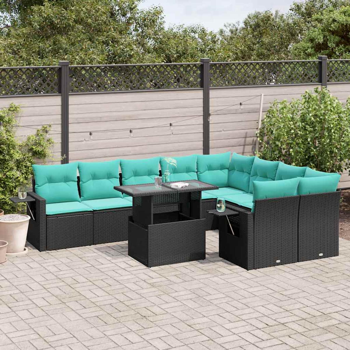 Gartenmöbel-Set aus Korbgeflecht mit türkisfarbenen Kissen. Enthält einen Tisch, zwei Sofas und Hintergrundgrün und einen Zaun.