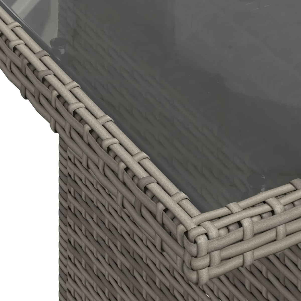Nahaufnahme eines grauen Korbtisches mit Glasplatte. Das Korbgeflecht hat ein gewebtes Muster. Das Glas reflektiert Licht.
