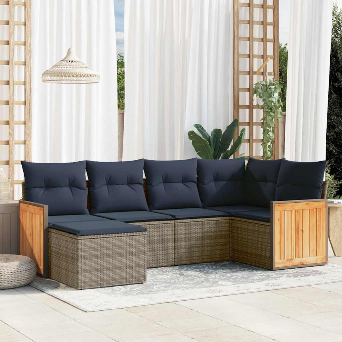 Outdoor-Ecksofa mit marineblauen Kissen. Holzrahmen, graue Korbbasis, auf einem hellen Teppich. Weiße Vorhänge und Hängelampe im Hintergrund.