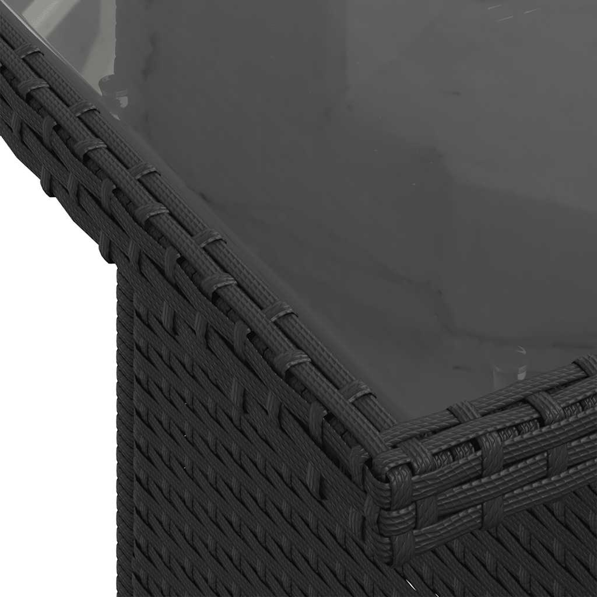 Nahaufnahme eines schwarzen Korbtisches. Die Oberseite ist klar und reflektierend und zeigt die Ecke des Tisches. Das Korbgeflecht hat eine gewebte Textur.