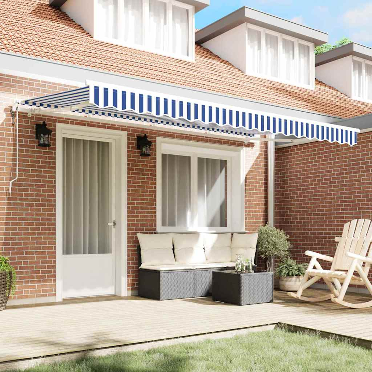 Ein Haus mit gestreifter Markise, Veranda mit Möbeln und Rasen. Ein Schaukelstuhl ist sichtbar.