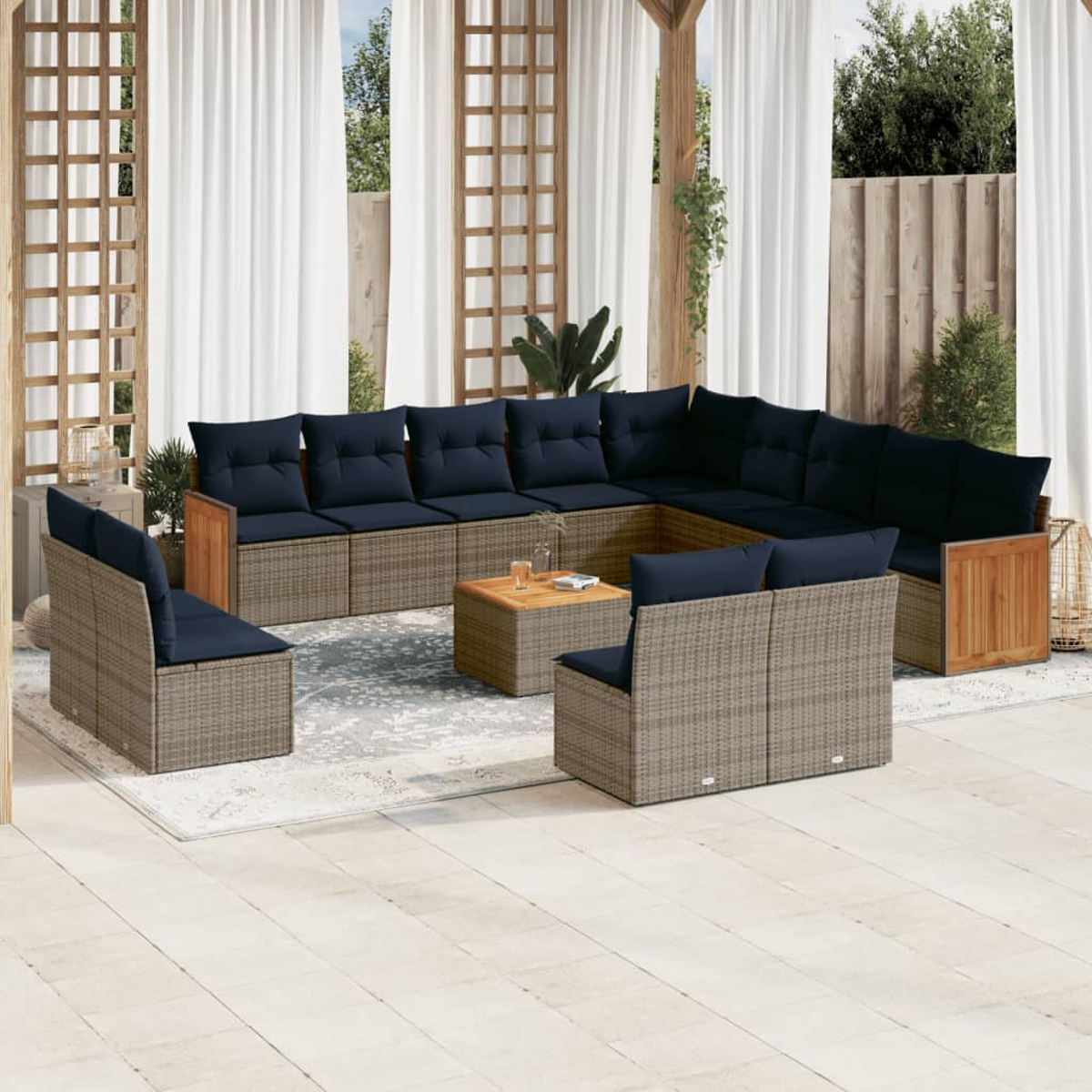 Außenbereich mit großem Ecksofa, zwei Stühlen und einem Couchtisch. Marineblaue Kissen und Rattanmöbel.
