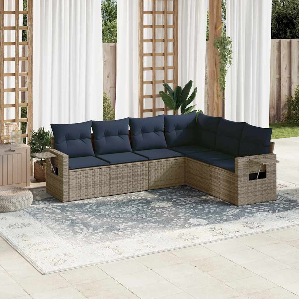 Ein Ecksofa mit blauen Kissen steht auf einem gemusterten Teppich. Weiße Vorhänge und ein Holzgitter befinden sich im Hintergrund.
