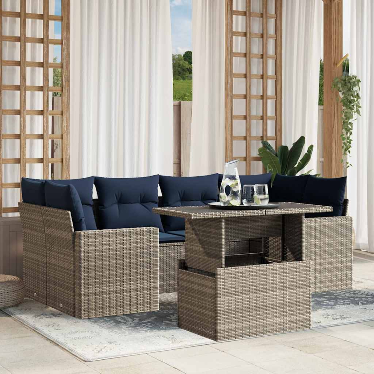 Gartenmöbel-Set mit Korbstruktur. Enthält Sofa mit blauen Kissen, Tisch mit Gläsern und Wasser und weiße Vorhänge.