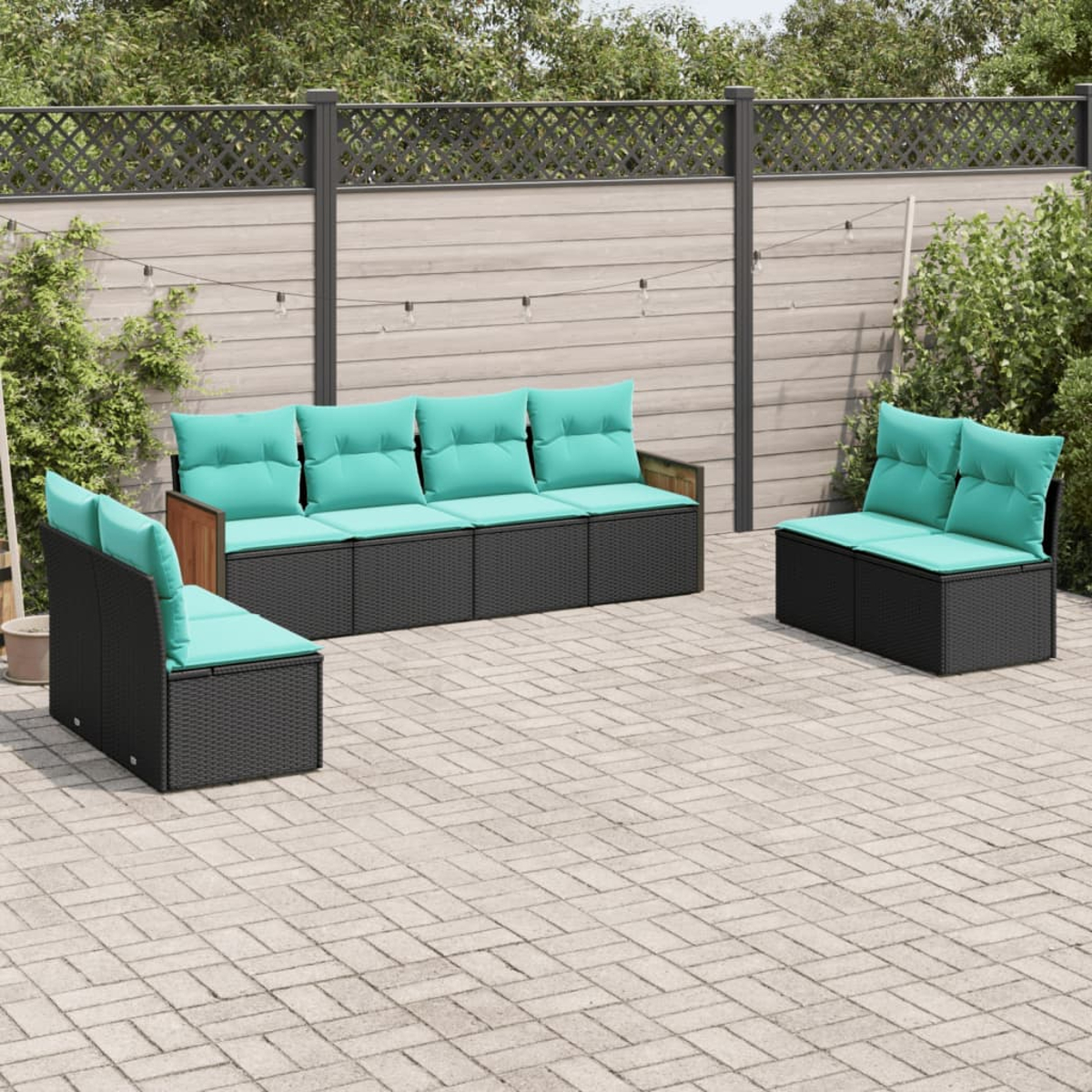 Juego de muebles de patio. Asientos de mimbre negro con cojines turquesa. Incluye un sofá y dos sillas en un patio pavimentado.