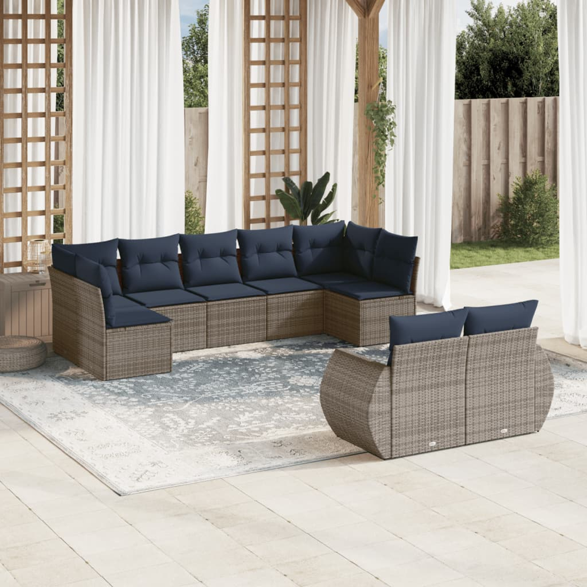 Outdoor-Ecksofa mit marineblauen Kissen auf einem gemusterten Teppich. Weiße Vorhänge und Holzgitter im Hintergrund.
