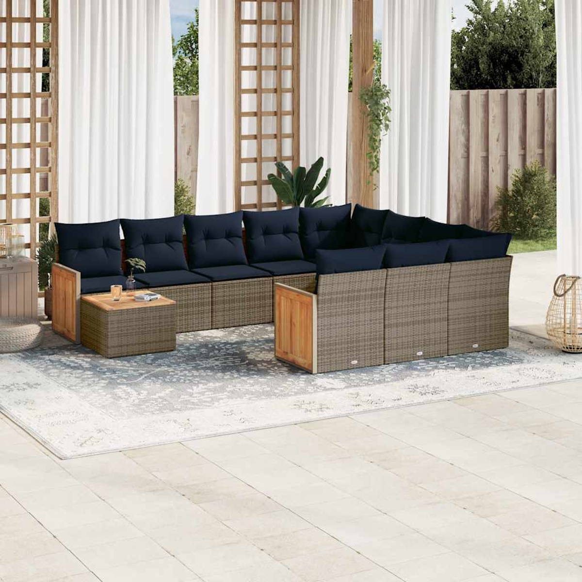 Outdoor-Sitzgruppe mit marineblauen Kissen, braunem Korbgeflecht, Holzakzenten und einem gemusterten Teppich auf einer Terrasse.