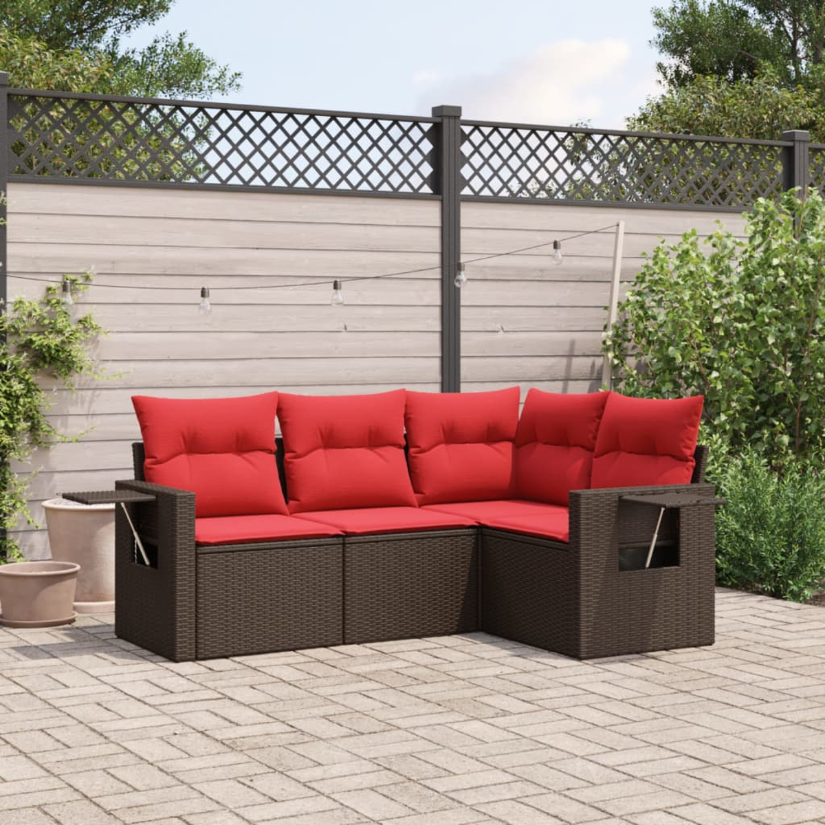 Ein Ecksofa im Freien mit roten Kissen steht auf einer Ziegelterrasse. Ein Holzzaun und Grünzeug sind im Hintergrund.