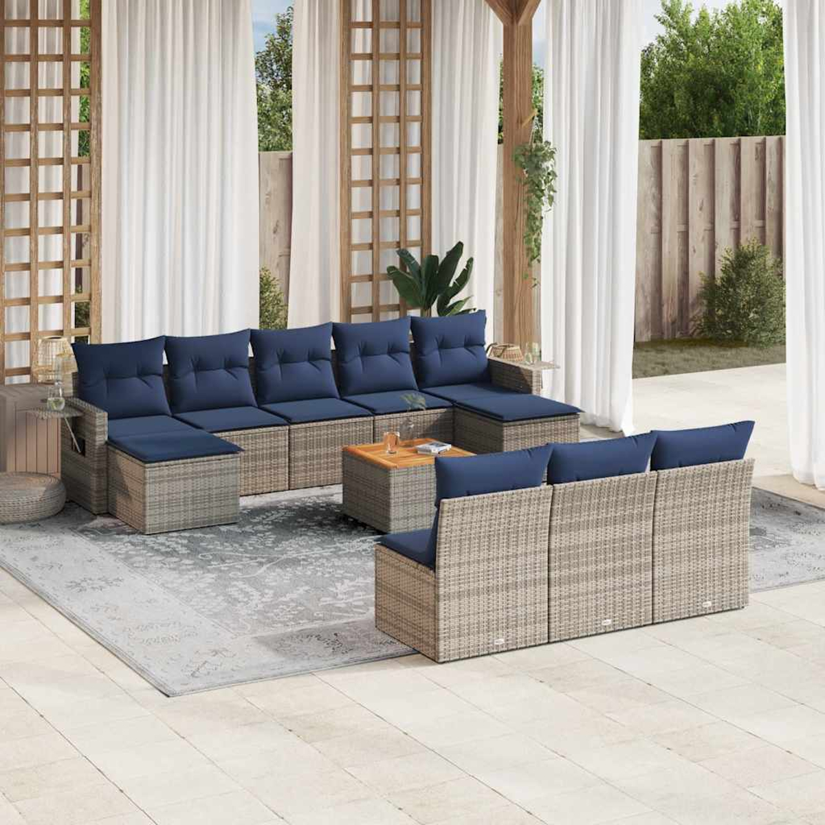 Gartenmöbel-Set mit blauen Kissen. Enthält Sofa, Ottomanen und Couchtisch. Auf einer Terrasse mit Vorhängen und Holzakzenten.