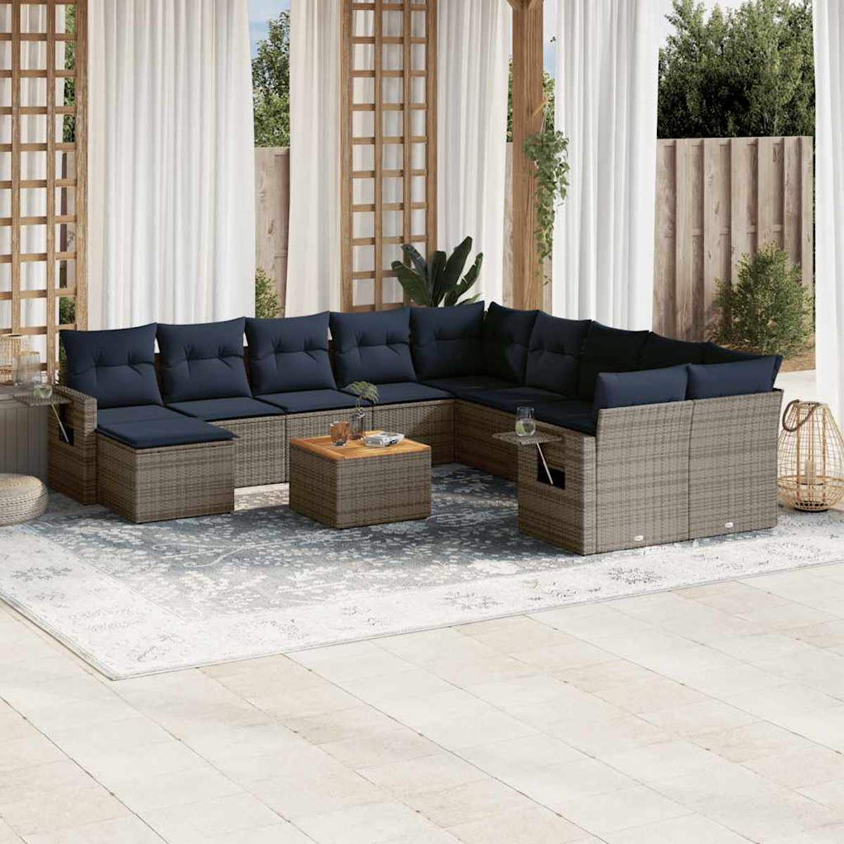 Outdoor-Ecksofa mit marineblauen Kissen. Couchtisch und Teppich. Weiße Vorhänge und Holzbalken schaffen einen Außenbereich.