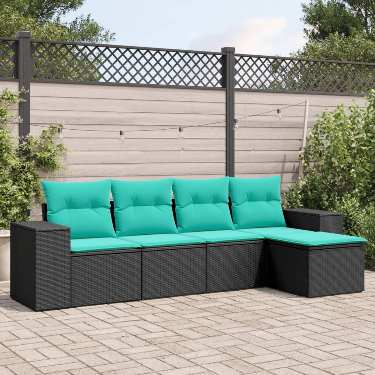 Schwarzes Rattan-Outdoor-Ecksofa mit türkisfarbenen Kissen steht auf einer Backstein-Terrasse. Im Hintergrund ein Zaun mit Kletterpflanzen.