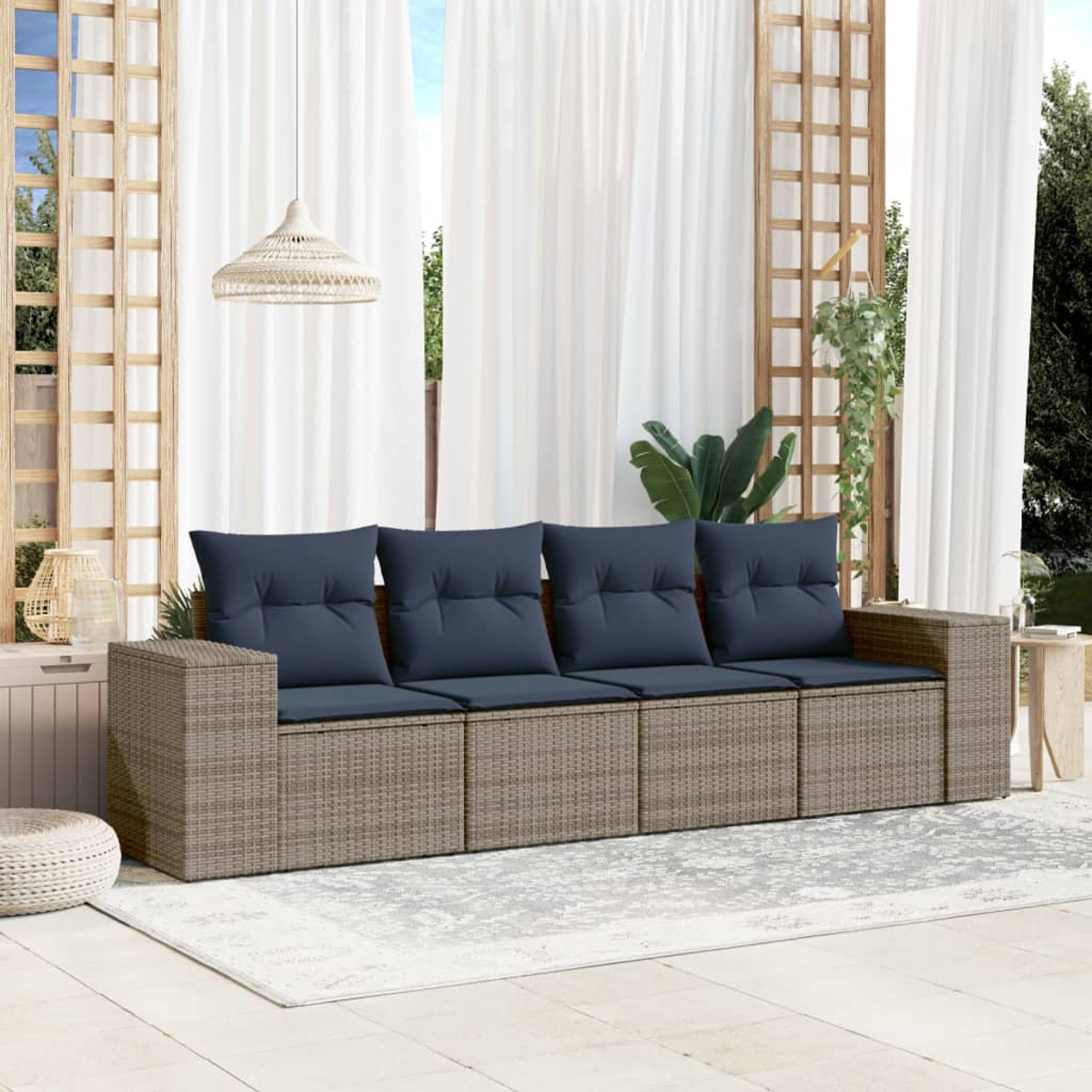 Outdoor-Szene mit einem Korbsessel mit blauen Kissen, weißen Vorhängen und einem gemusterten Teppich. Pflanzen und Holzstrukturen sind sichtbar.