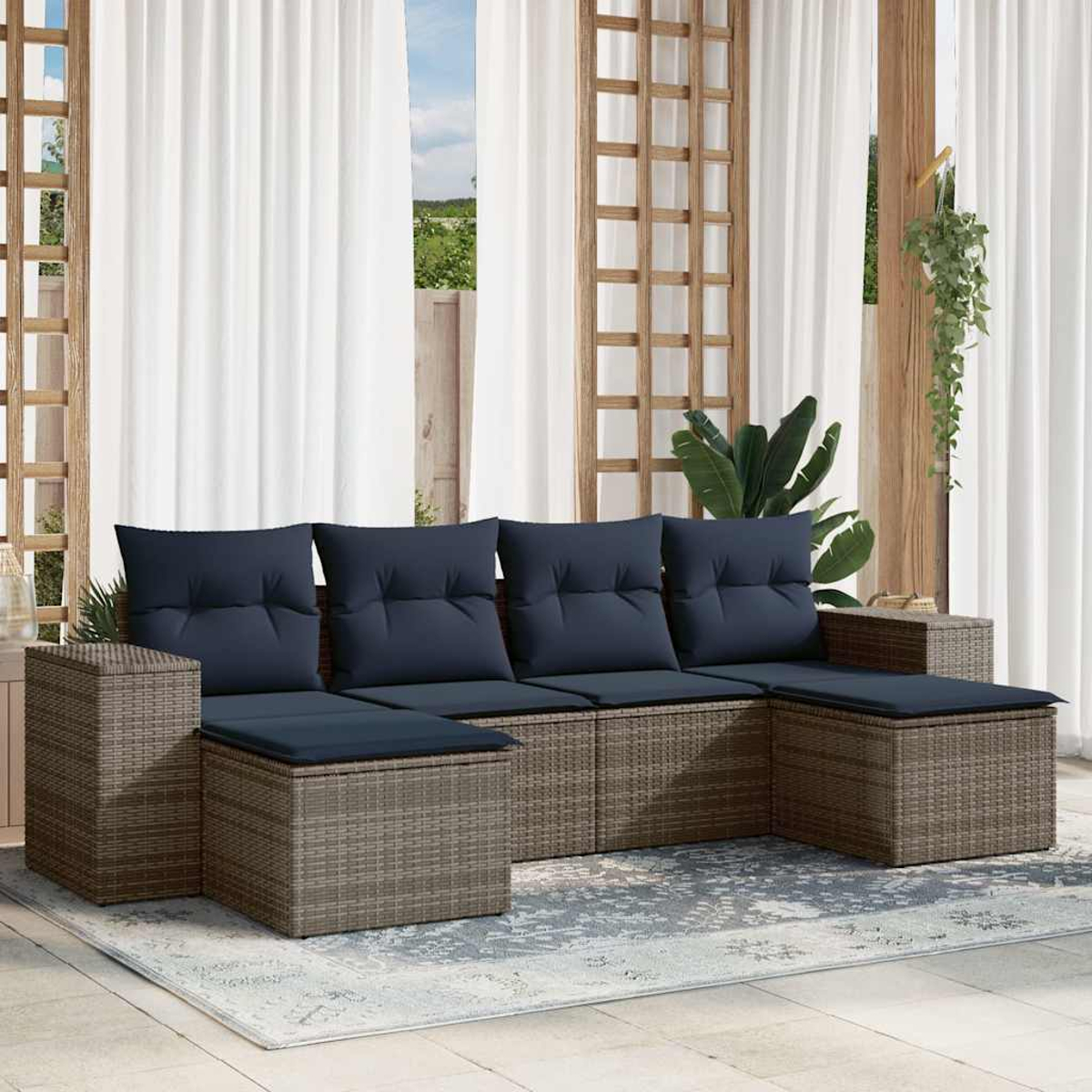 Outdoor-Ecksofa mit marinefarbenen Kissen auf einem Teppich. Weiße Vorhänge und Holzgitter im Hintergrund. Pflanzen hängen.