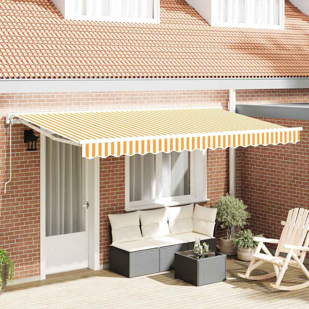 Ein gestreifter orange-weißer Markisenstoff bedeckt eine Terrasse mit weißer Tür, Sofa, Tisch und Schaukelstuhl. Im Hintergrund ein Backsteingebäude.