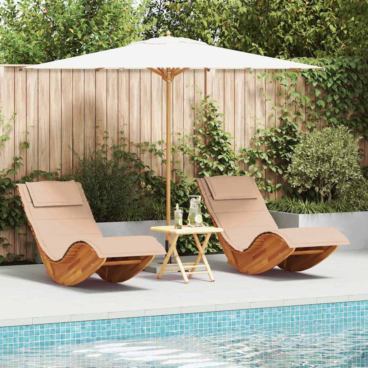 Dos tumbonas de madera con cojines beiges bajo una sombrilla blanca. Una pequeña mesa con bebidas entre ellas, piscina al frente.