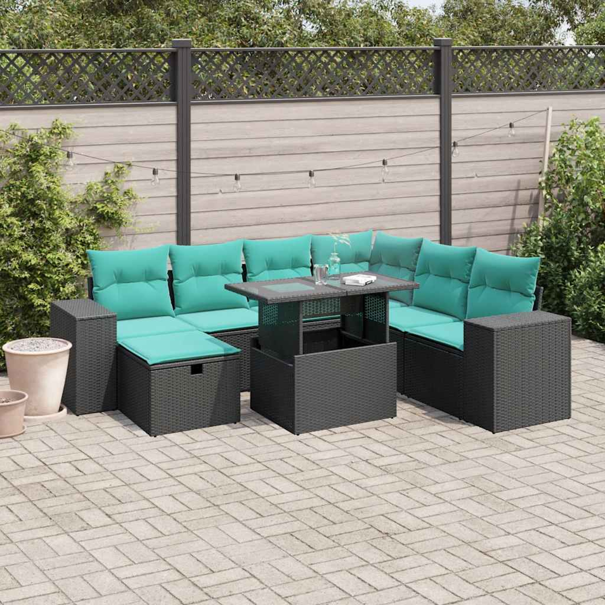 Outdoor-Ecksofa mit türkisfarbenen Kissen und Couchtisch. Auf einer Ziegelterrasse mit Zaun und Pflanzen im Hintergrund.