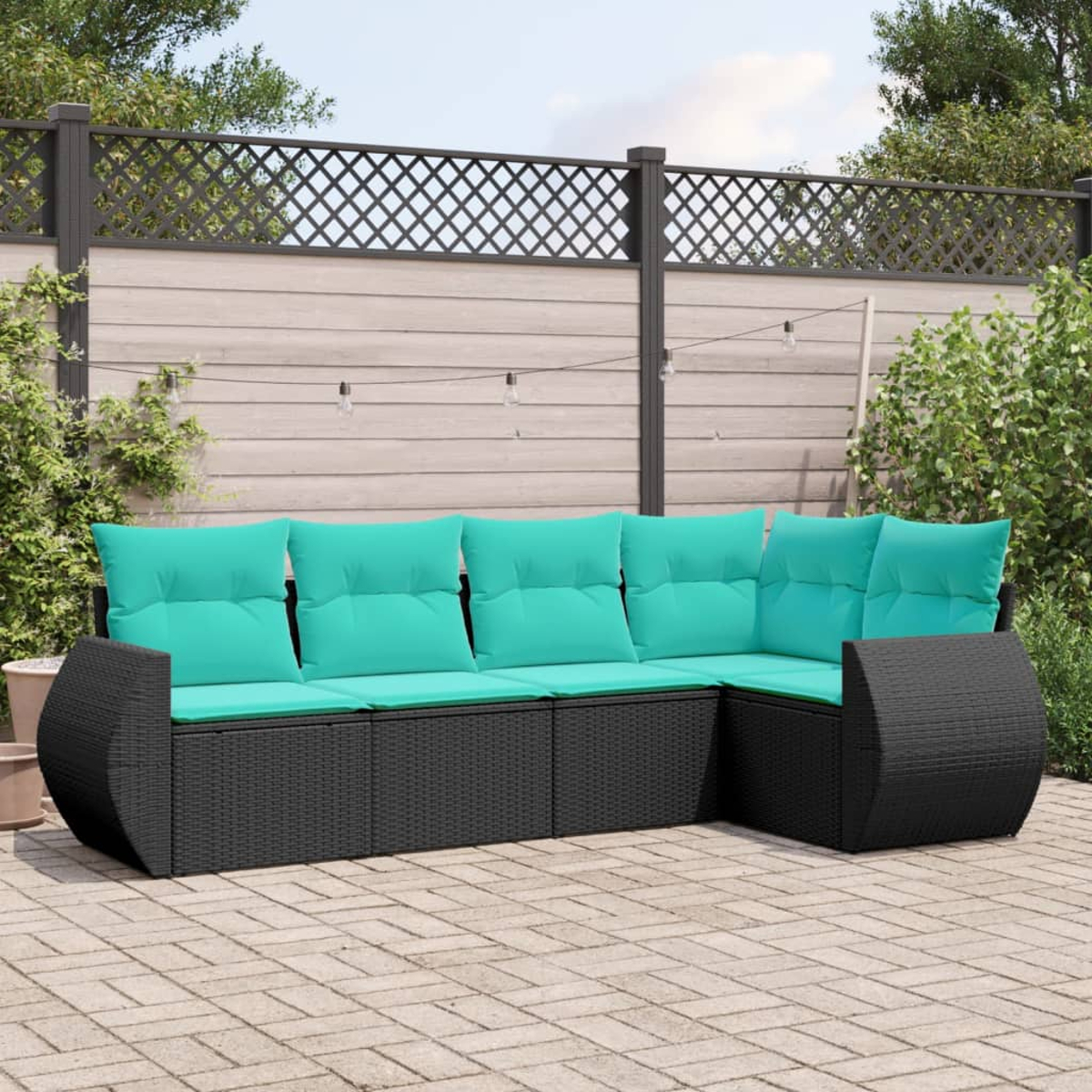 Ein Ecksofa im Freien mit türkisfarbenen Kissen. Das Sofa ist aus schwarzem Korbgeflecht. Der Hintergrund zeigt einen Zaun und Grün.