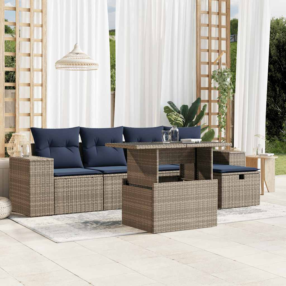 Juego de patio exterior con sofá, sillas y mesa. Cojines azules, muebles de mimbre beige, cortinas blancas y lámpara colgante.