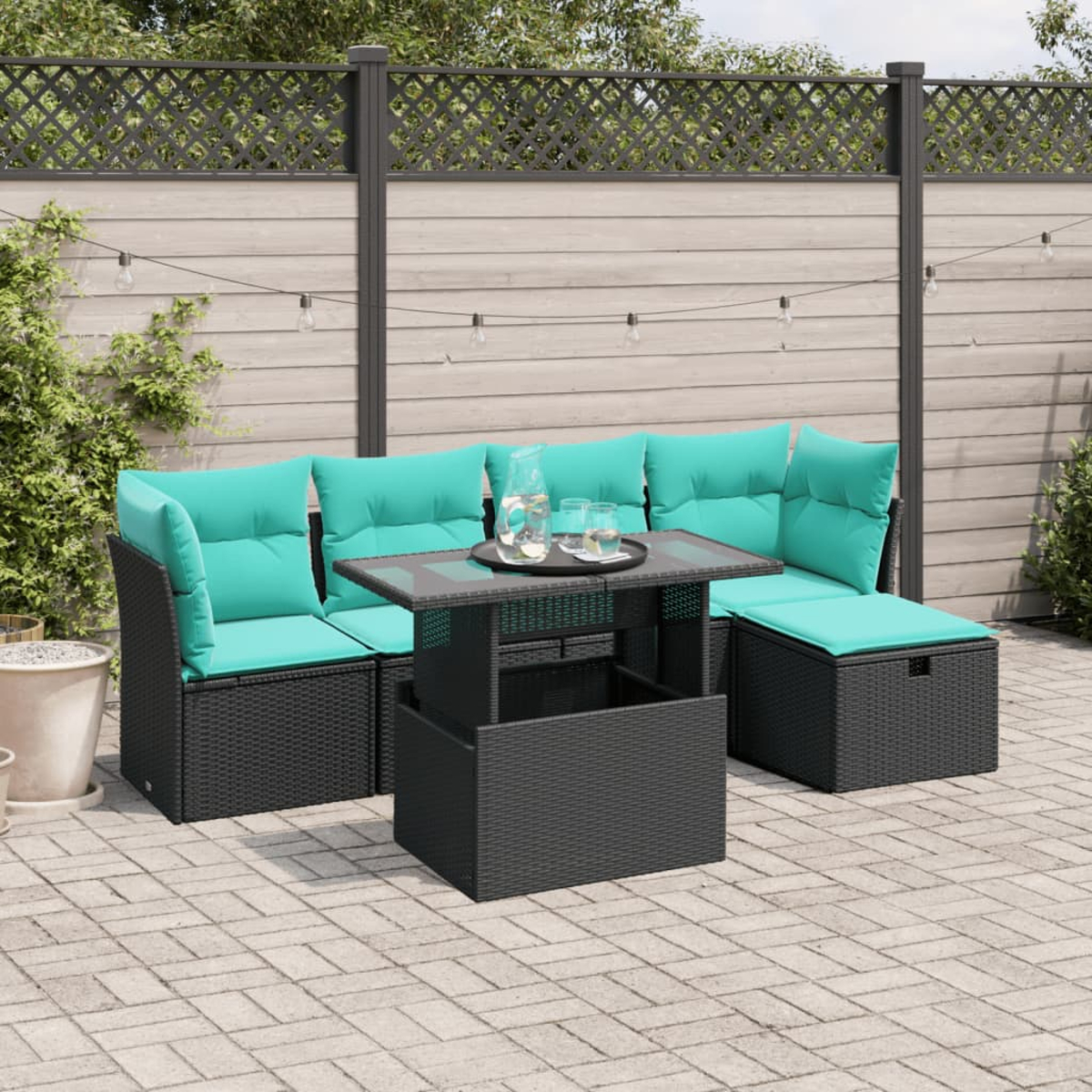 Garten-Sitzgruppe mit türkisfarbenen Kissen, schwarze Korbmöbel, Glastisch mit Getränken und Lichterketten auf der Terrasse.