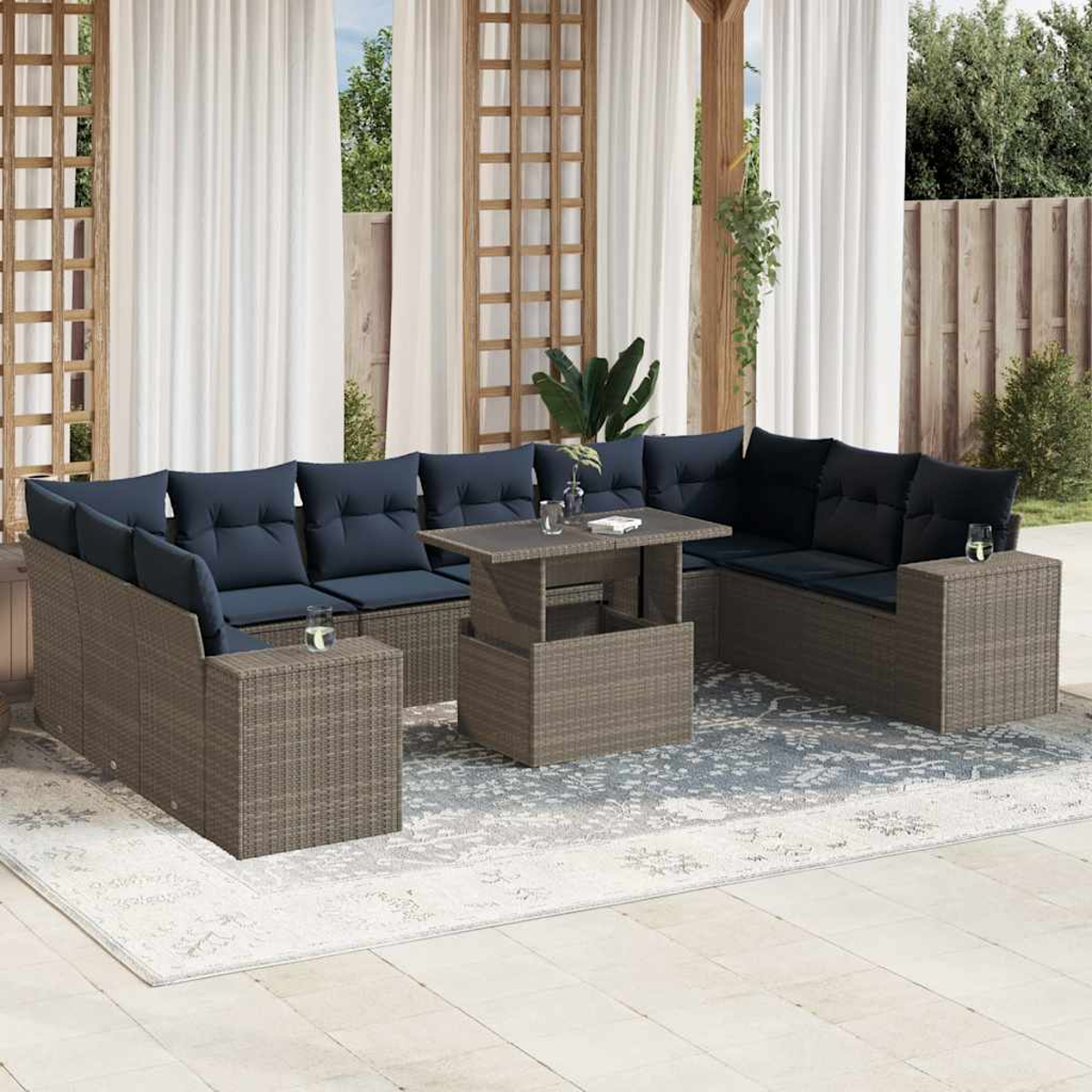 Outdoor-Ecksofa mit marineblauen Kissen und einem Tisch mit Hubfunktion auf einem Teppich, in der Nähe von weißen Vorhängen und einem Holzgitter.