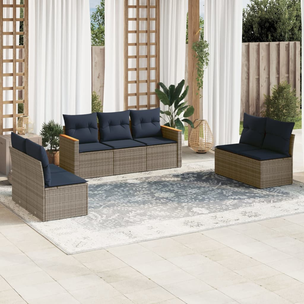 Garten-Terrassenset mit blauen Kissen auf einem gemusterten Teppich. Enthält ein Sofa, zwei Stühle, Pflanzen, weiße Vorhänge und Holzstrukturen.