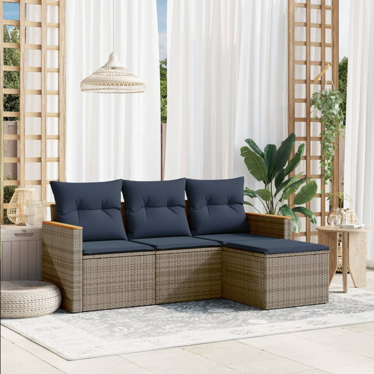 Outdoor-Ecksofa mit marineblauen Kissen. Weiße Vorhänge und eine Hängelampe darüber. Holzgitter und grüne Pflanzen.