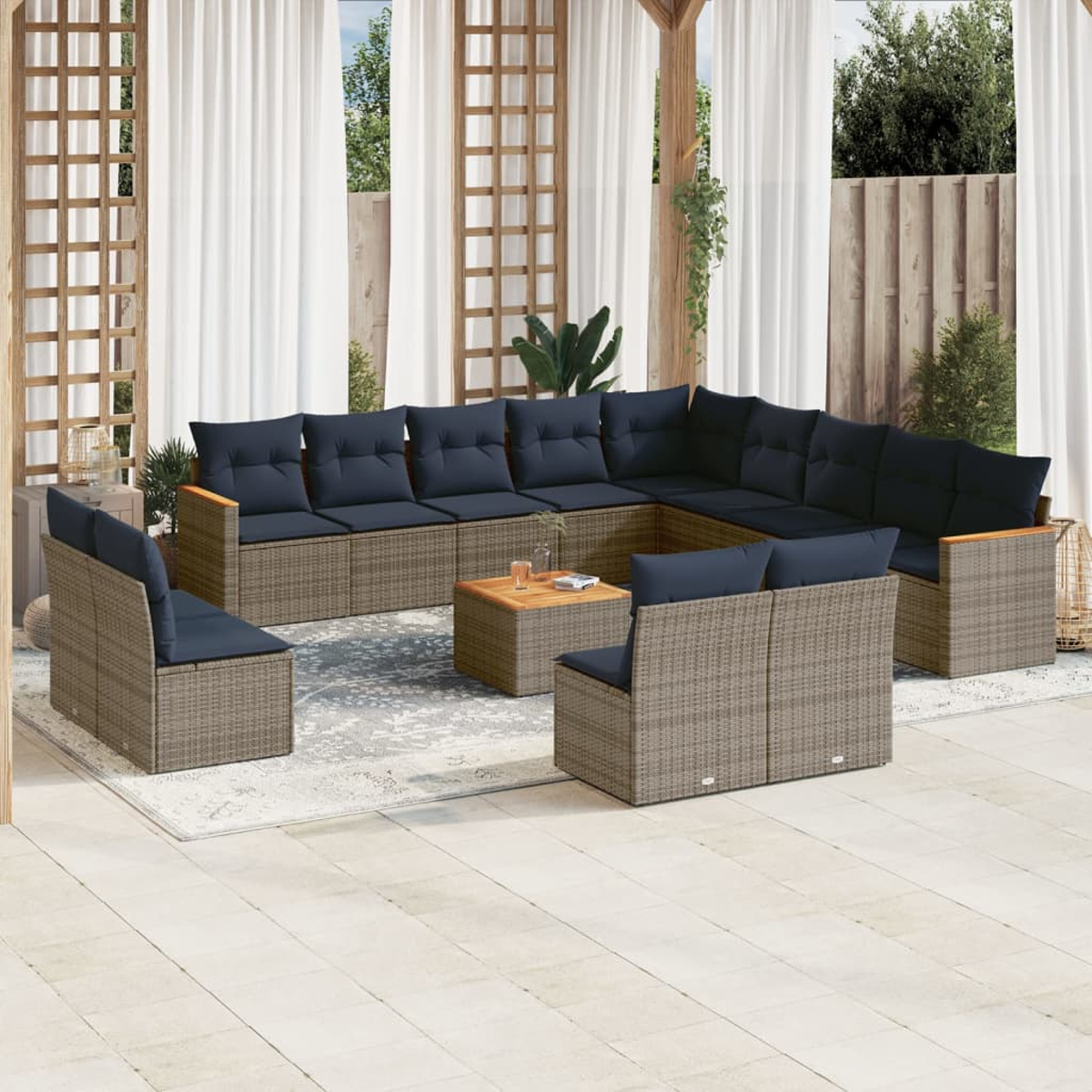 Juego de patio al aire libre con un gran sofá seccional, dos sillones y una mesa de centro. Cojines azul marino y muebles de mimbre.