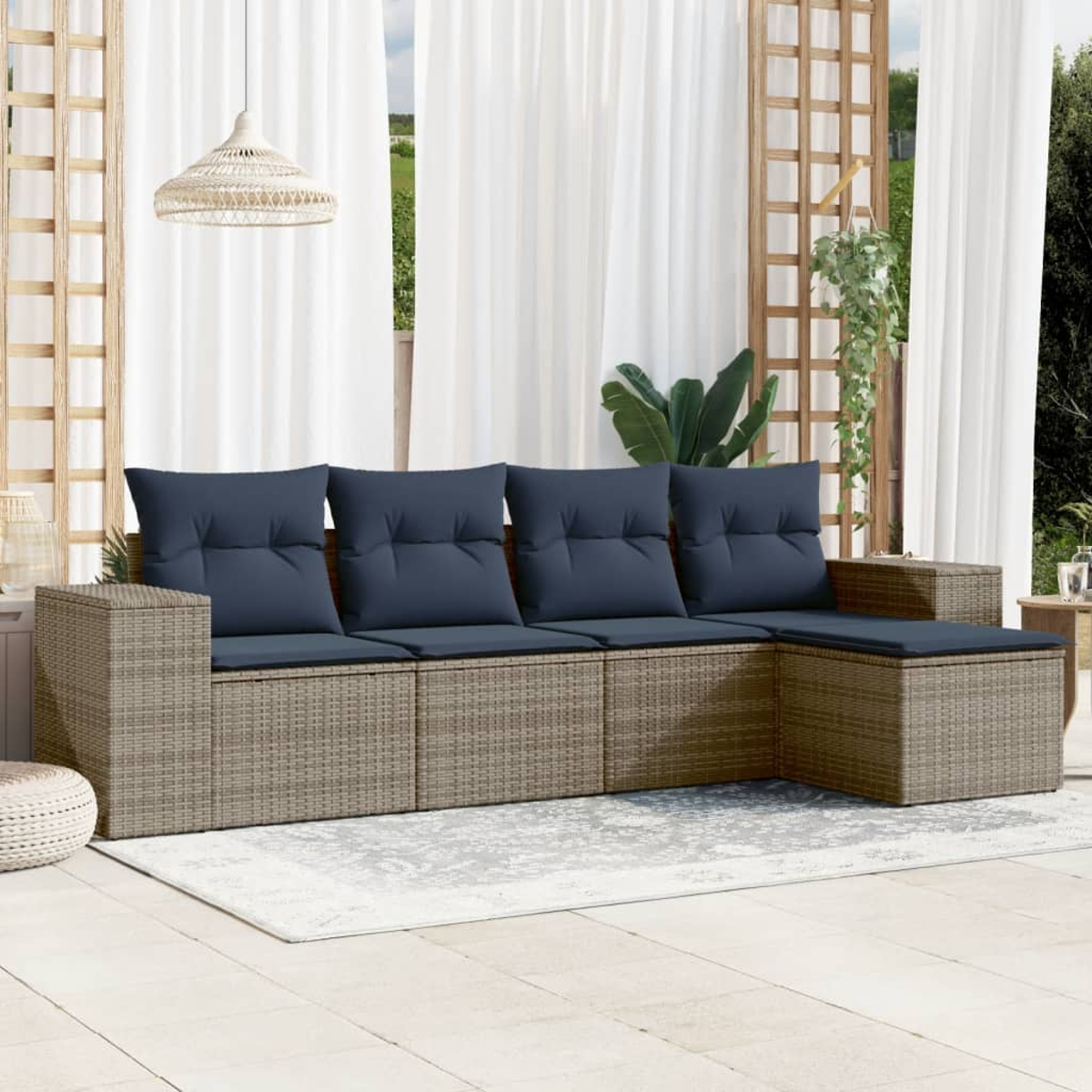 Outdoor-Ecksofa mit marineblauen Kissen, auf einem Teppich platziert, vor Vorhängen. Hängelicht und Grün sichtbar.