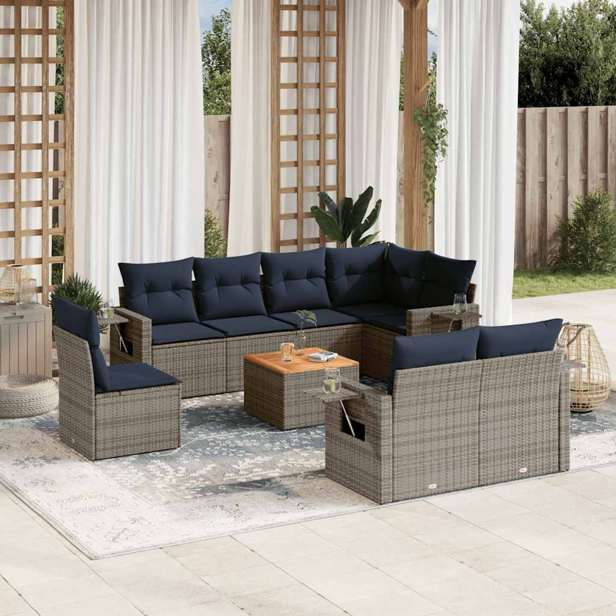Terrassenmöbel-Set mit grauem Korbmöbel und marineblauen Kissen. Enthält ein Ecksofa, Stühle und einen Couchtisch, auf einem Teppich.