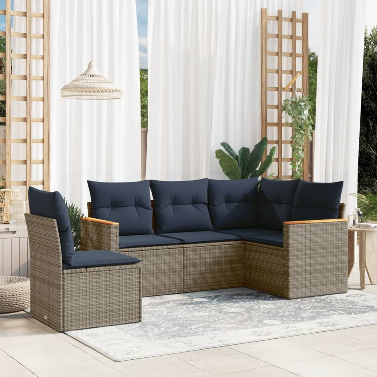 Outdoor-Sitzgruppe mit blauen Kissen. Enthält einen Stuhl und ein Ecksofa auf einem grauen Teppich, in der Nähe weißer Vorhänge.