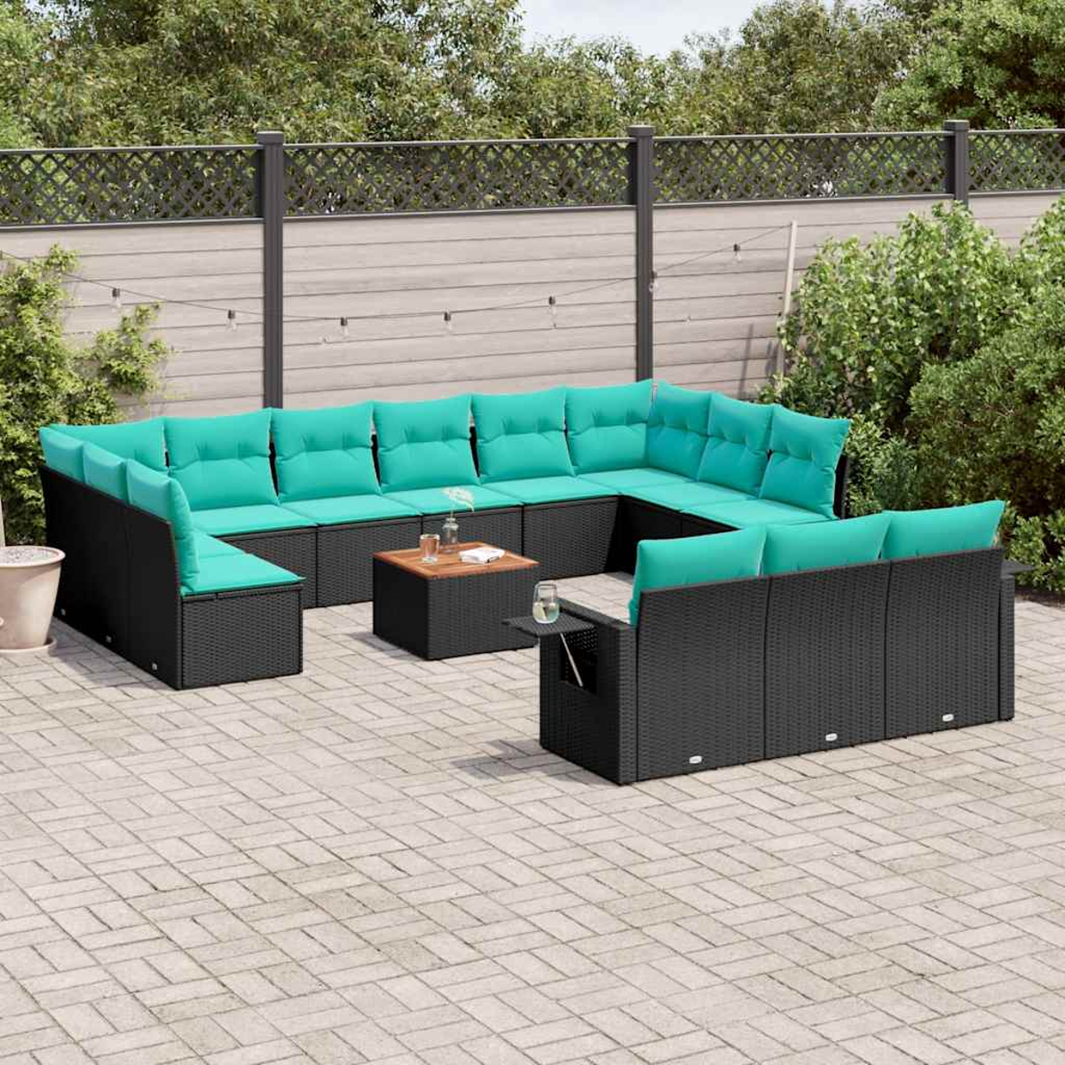 Outdoor-Ecksofa mit schwarzen Korbgeweben und tealfarbenen Kissen. Ein kleiner Tisch hält Getränke. Die Szene ist auf einer Backstein-Terrasse.