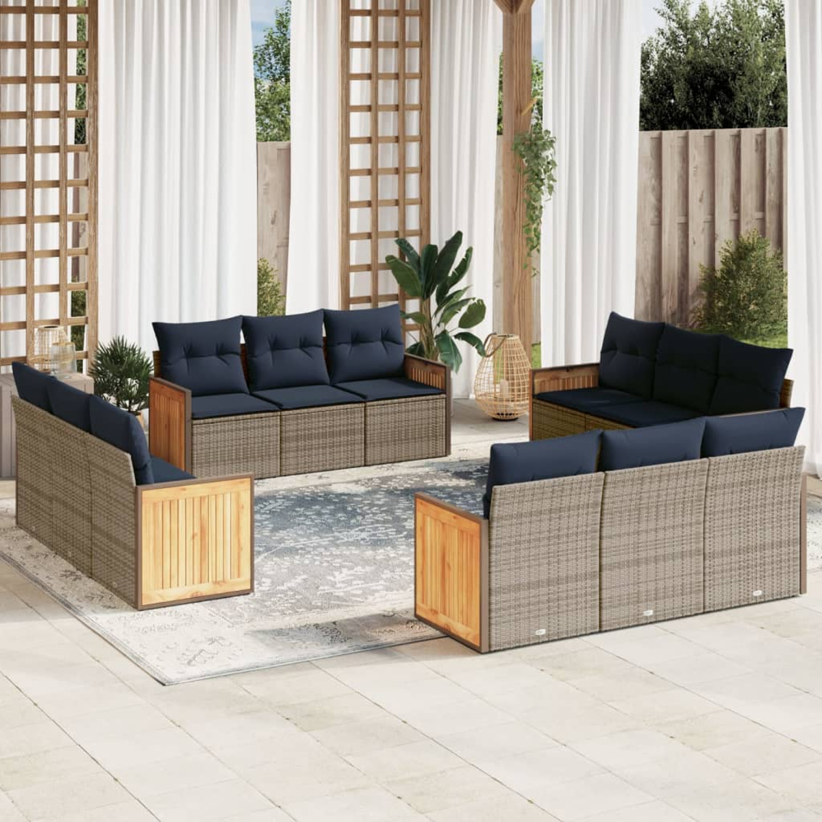 Garten-Sitzgruppe mit gewebten Seiten und Holzakzenten, marineblaue Kissen. Set umfasst Sofa, zwei Stühle und Loveseat auf Terrasse.
