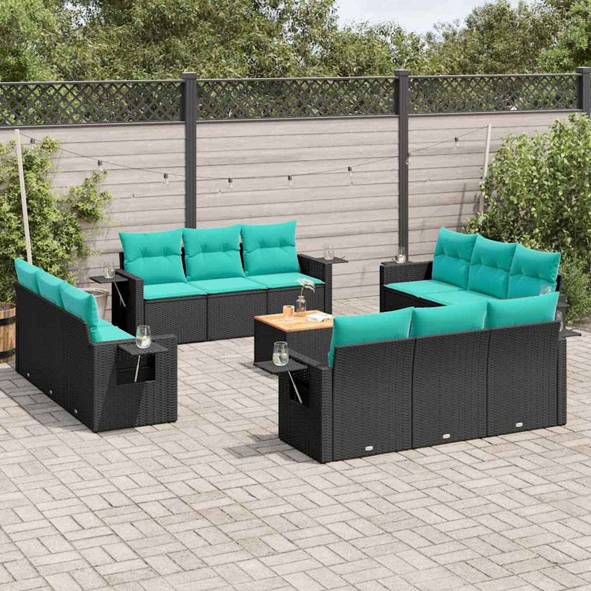 Garten-Set mit schwarzer Korbmöbeln, türkisfarbenen Kissen und einem kleinen Holztisch auf einer Backstein-Terrasse.