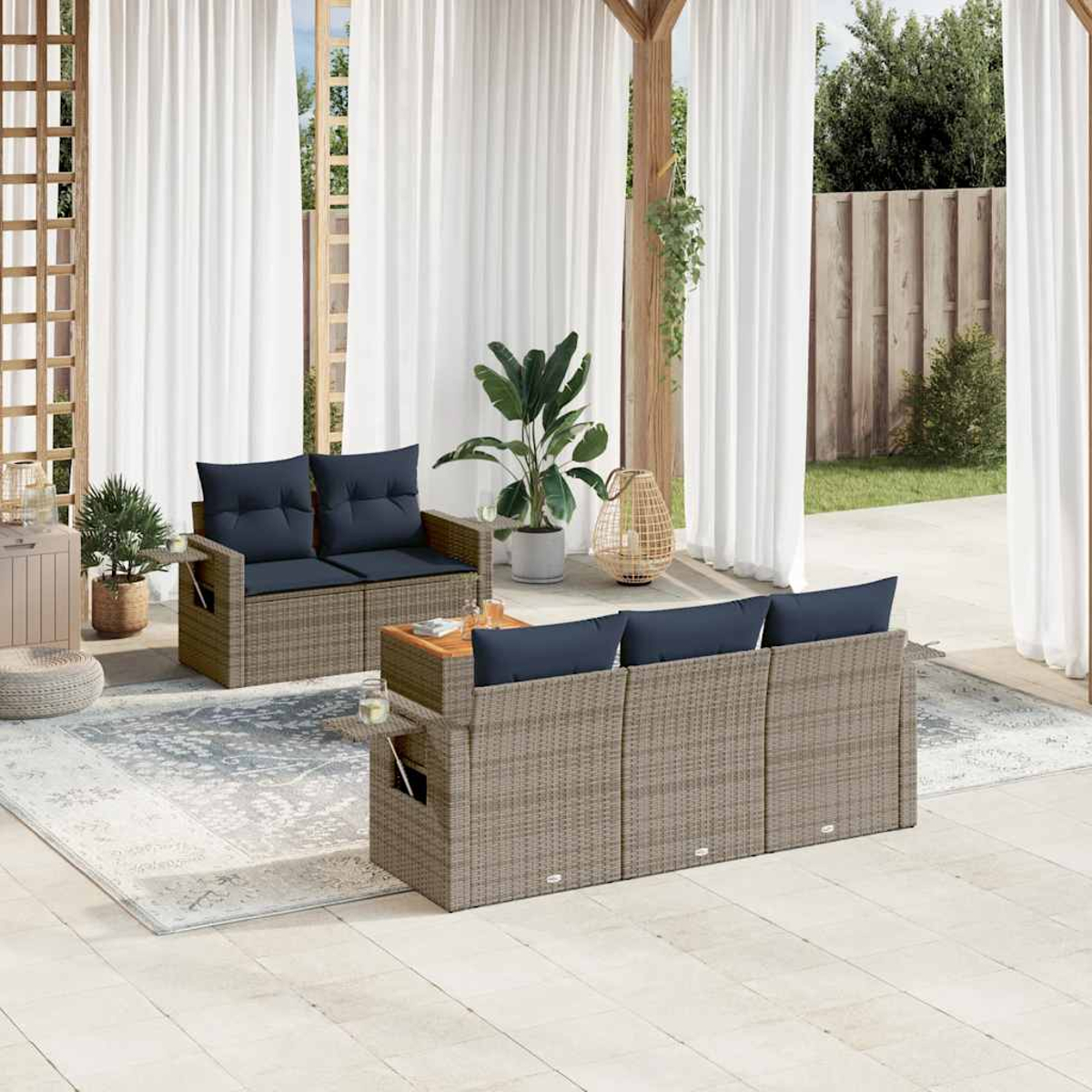 Terrasse mit Rattansofas, marinefarbenen Kissen, Teppich, Pflanzen und transparenten Vorhängen. Ein entspannender Außenbereich.