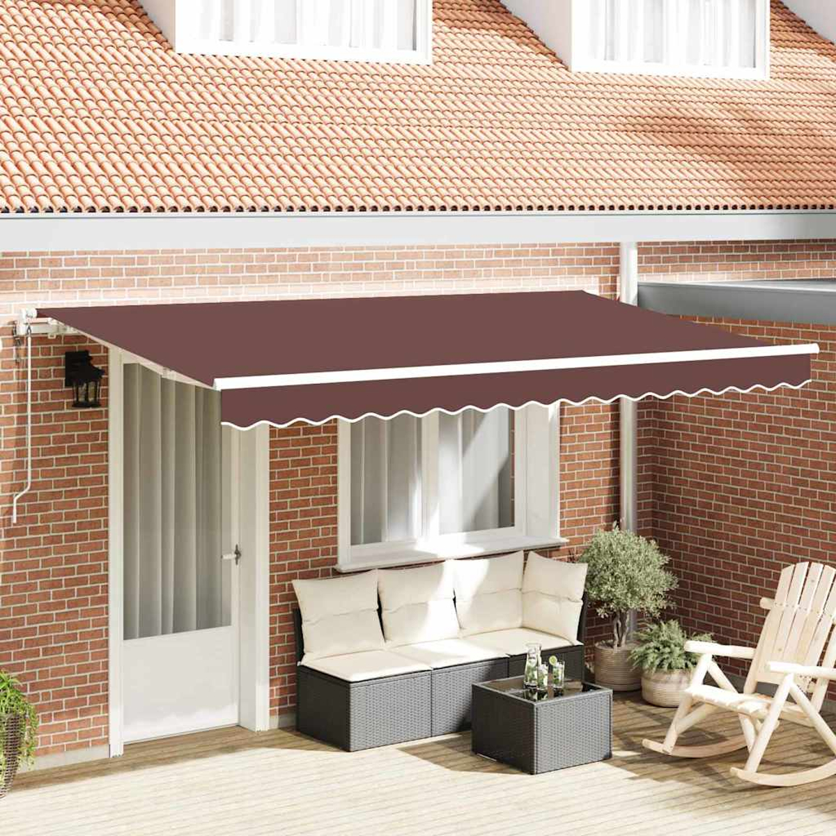 Un toldo marrón sobre un patio con paredes de ladrillo. Se ven una puerta blanca, un sofá, una mesa, plantas y una mecedora.